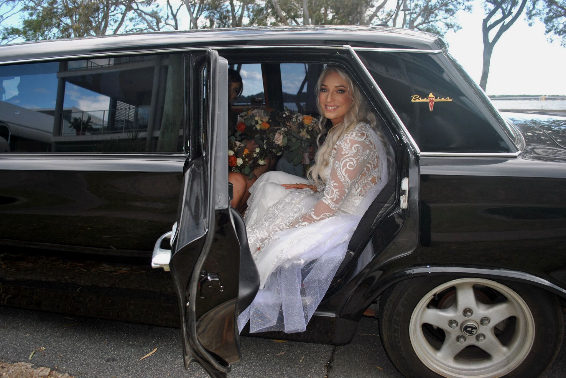 Beautiful Bride Sitting In Car With Flowers About To Get Married — Noosa Premier Stretch Holden Transfers In Brisbane, QLD