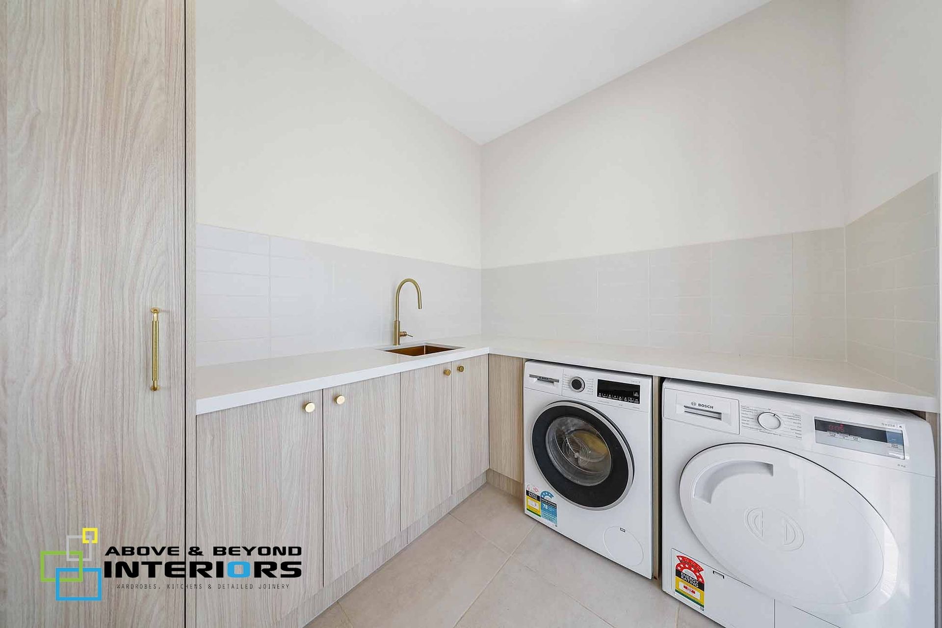 Laundry Room With Washer, Dryer, Sink, and Cabinets; Light Woodgrain Finish — Above & Beyond Interiors in Smeaton Grange, NSW