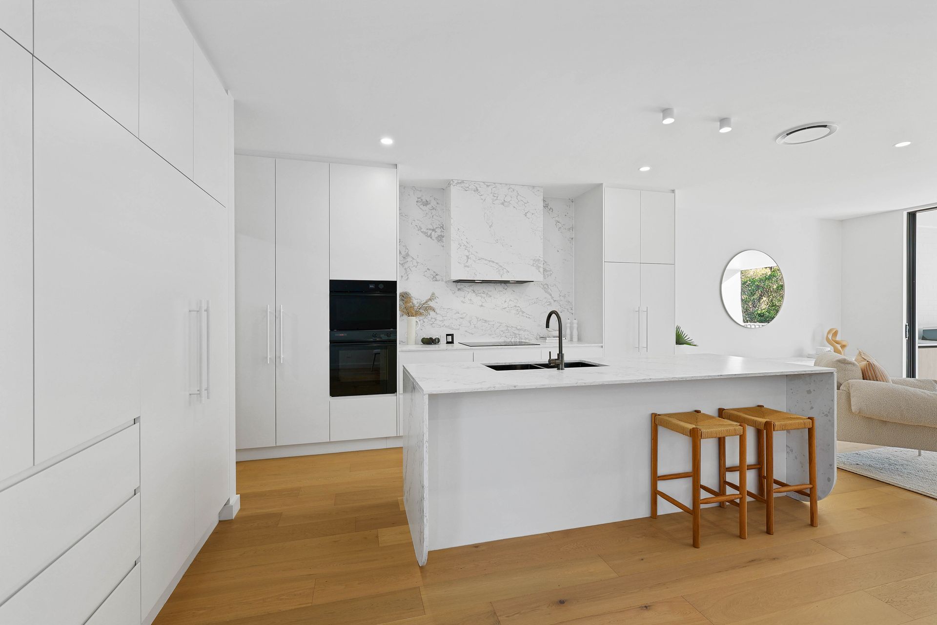Bright White Modern Kitchen With Wood Floors — Above & Beyond Interiors in Smeaton Grange, NSW