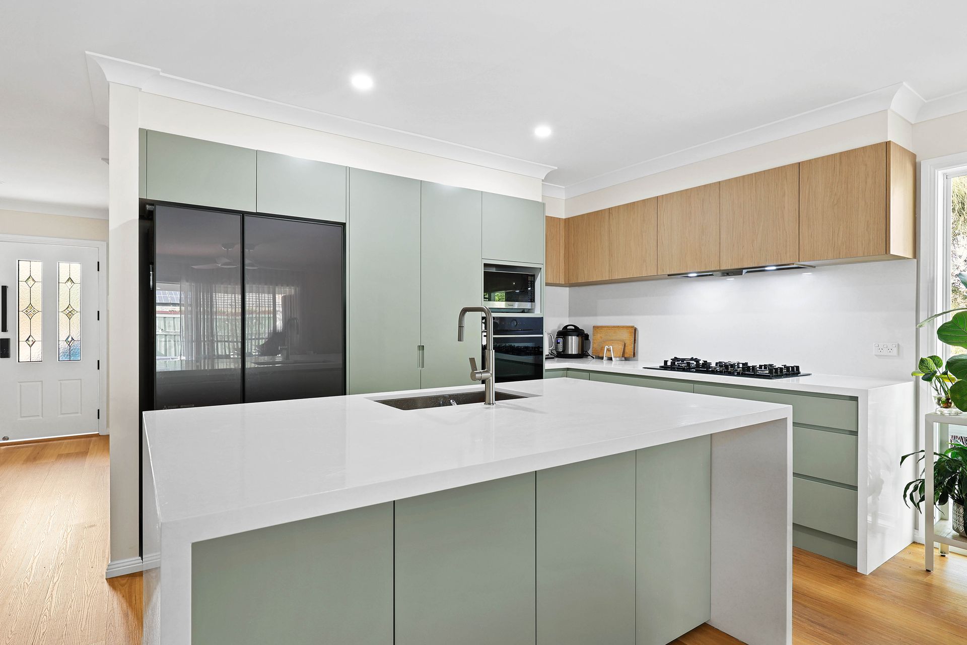 Modern Kitchen With Sage Cabinets, White Island — Above & Beyond Interiors in Smeaton Grange, NSW