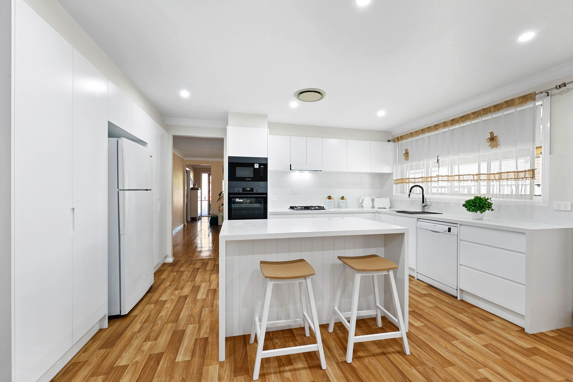 Bright Modern White Kitchen with Island — Above & Beyond Interiors in Smeaton Grange, NSW