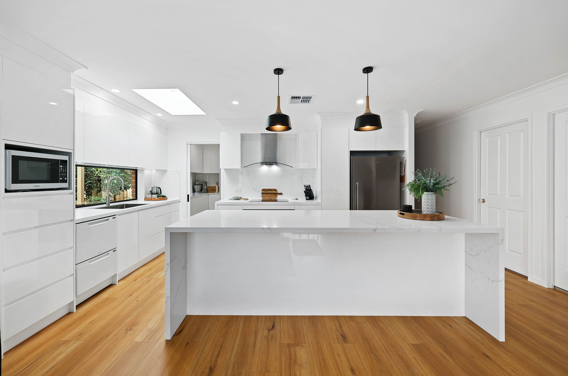 Bright White Modern Kitchen with Island — Above & Beyond Interiors in Smeaton Grange, NSW