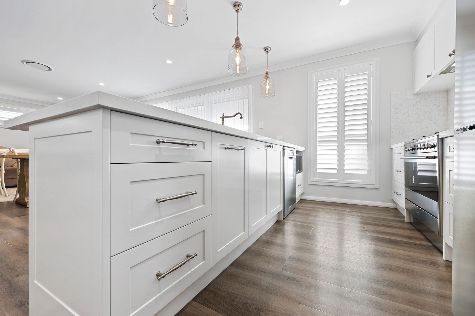A Kitchen with Stainless Appliances, and Wood-Look Flooring — Above & Beyond Interiors in Smeaton Grange, NSW