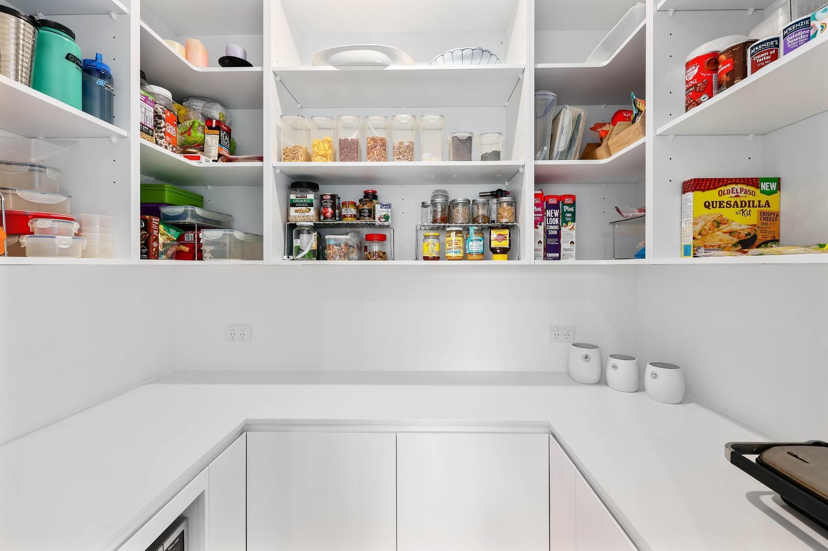 Bright White Kitchen Pantry with Open Shelves Stocked — Above & Beyond Interiors in Smeaton Grange, NSW