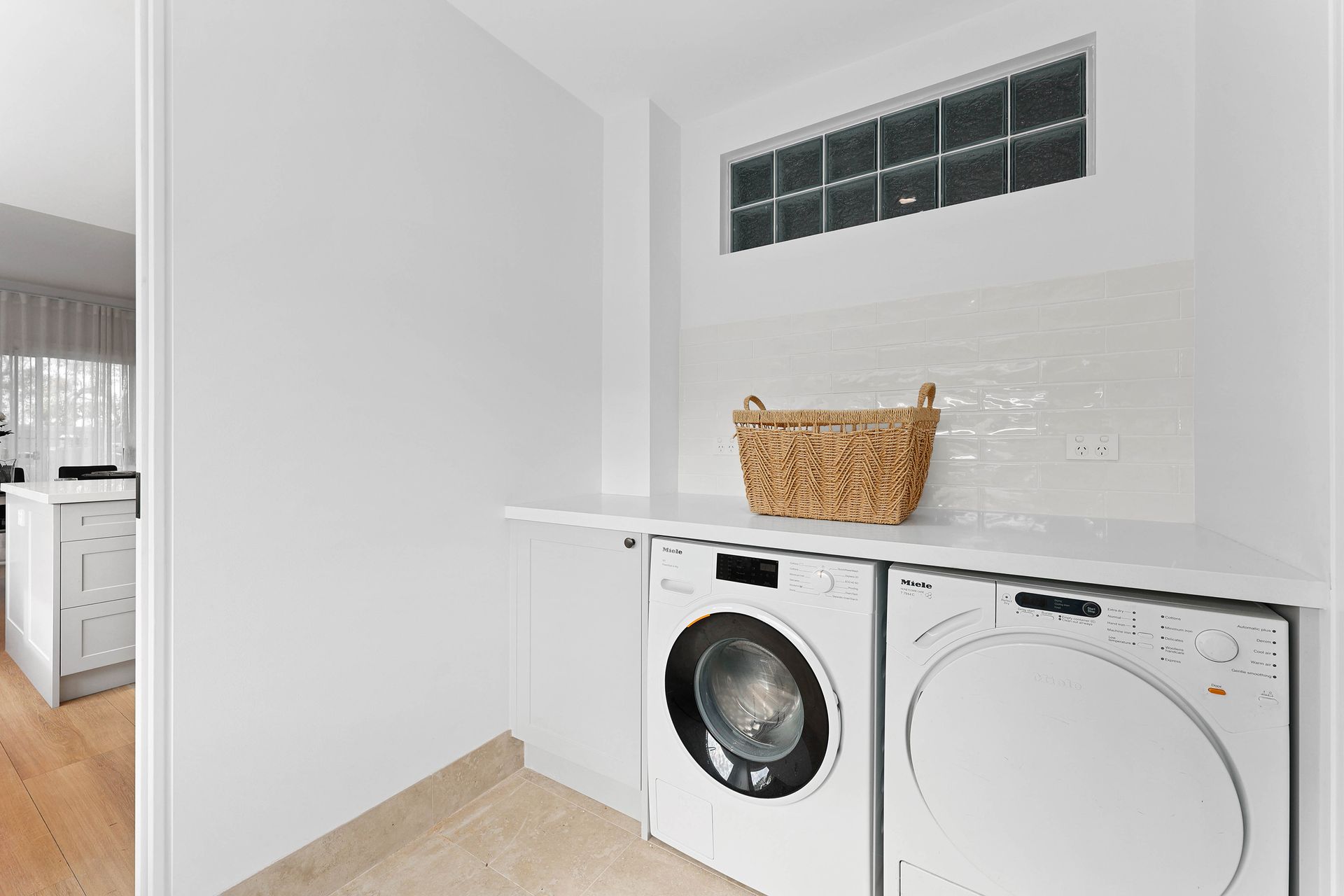 Laundry Room with White Washer and Dryer Under a Shelf — Above & Beyond Interiors in Smeaton Grange, NSW