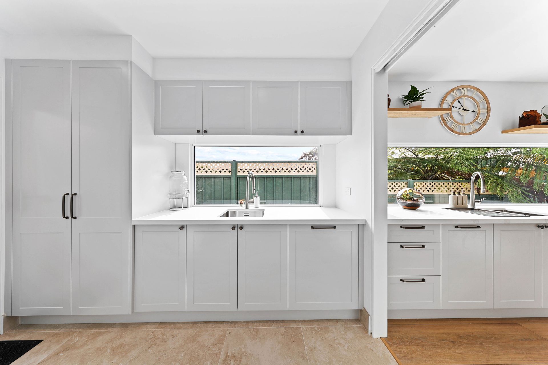 A Kitchen with Gray Cabinets, Window Sink, and Open Shelving — Above & Beyond Interiors in Smeaton Grange, NSW