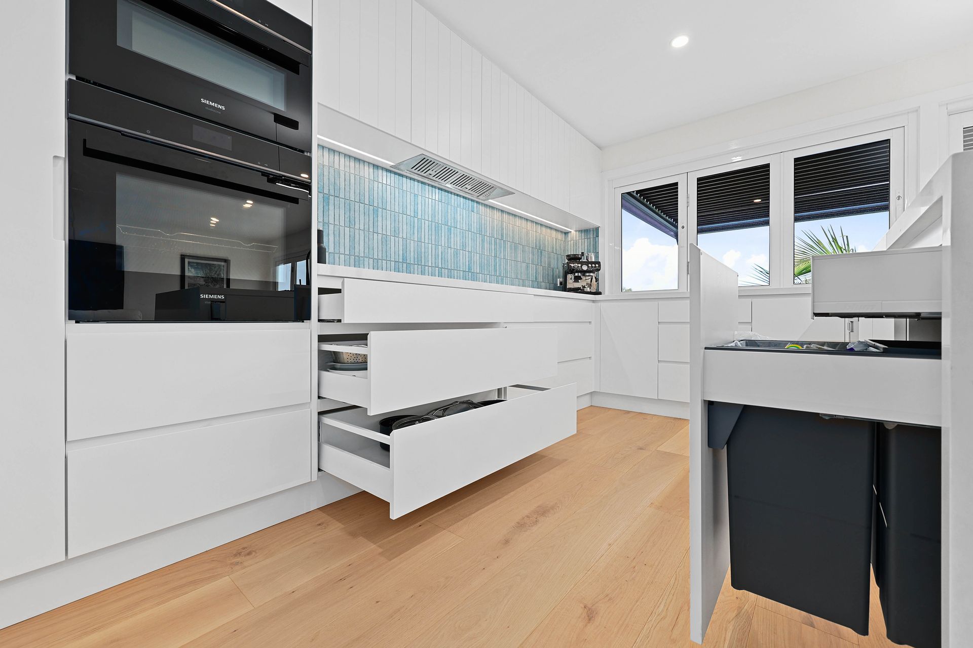 Modern White Kitchen with Black Appliances — Above & Beyond Interiors in Smeaton Grange, NSW