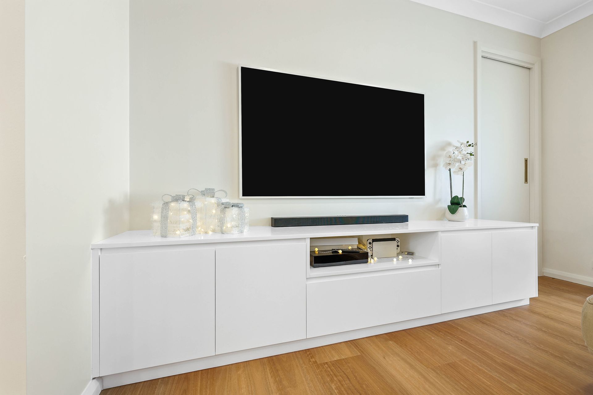 Modern Living Room With a Large Wall-mounted TV — Above & Beyond Interiors in Smeaton Grange, NSW