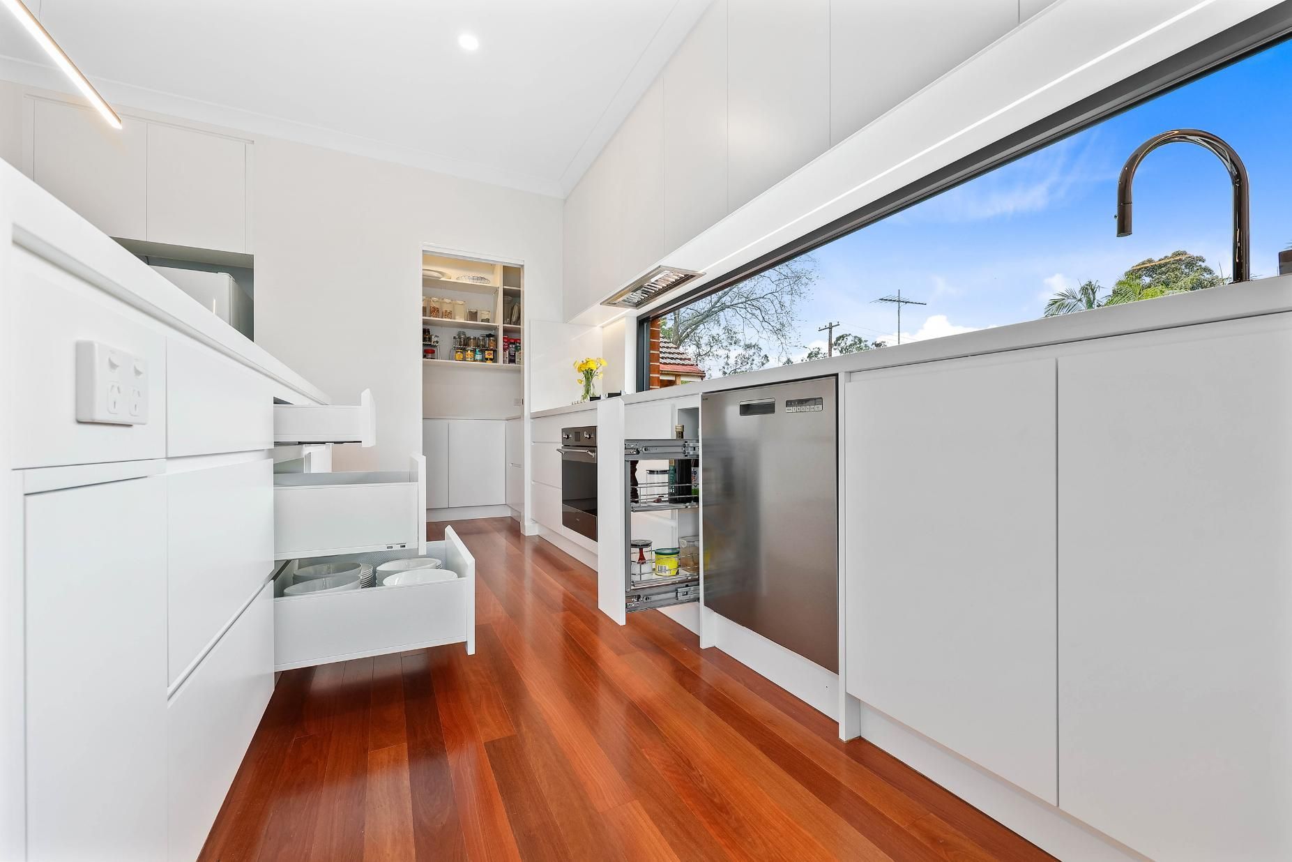 Bright Modern Kitchen with White Cabinets and Stainless Appliances — Above & Beyond Interiors in Smeaton Grange, NSW