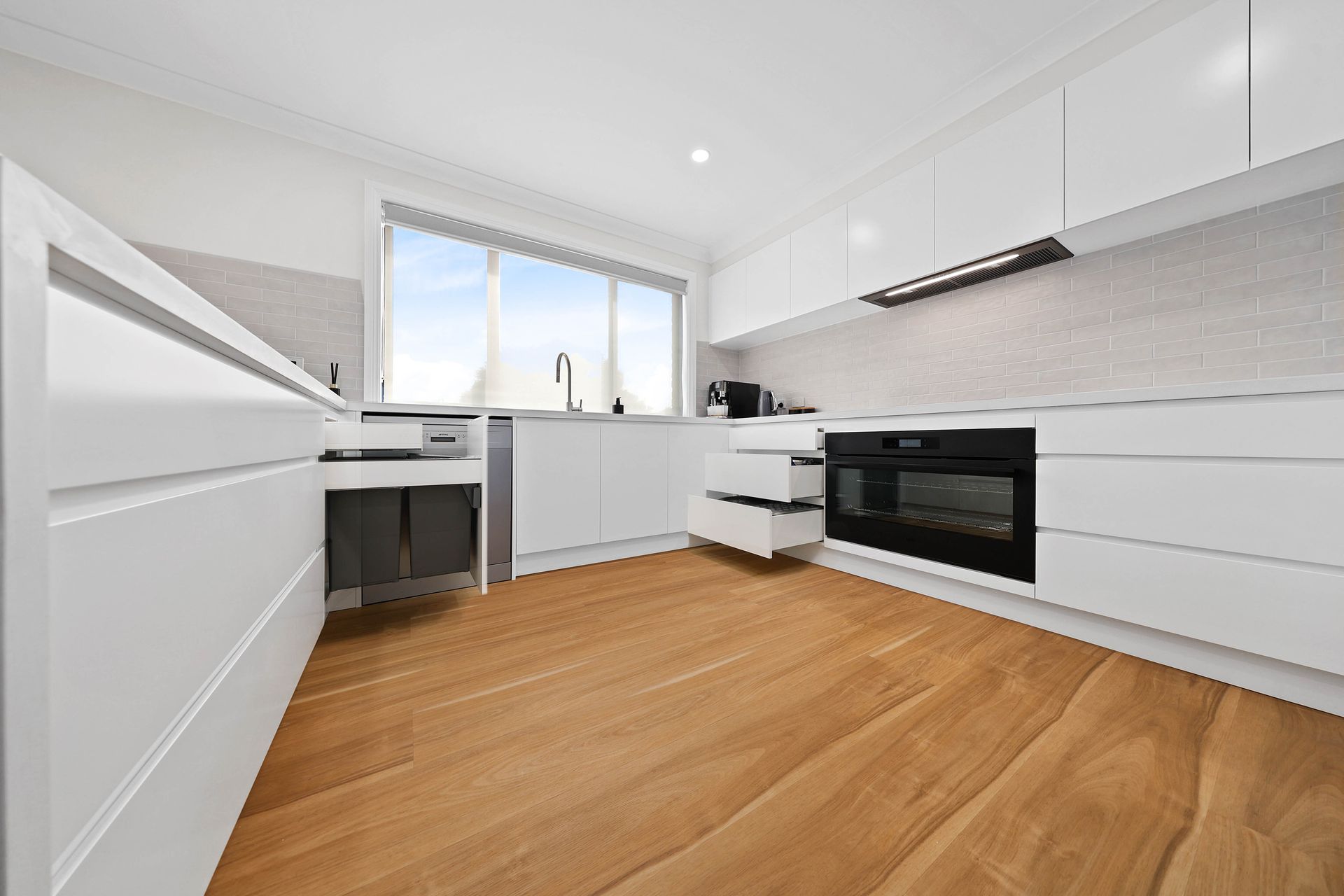 Bright Modern White Kitchen with Wood Floors — Above & Beyond Interiors in Smeaton Grange, NSW