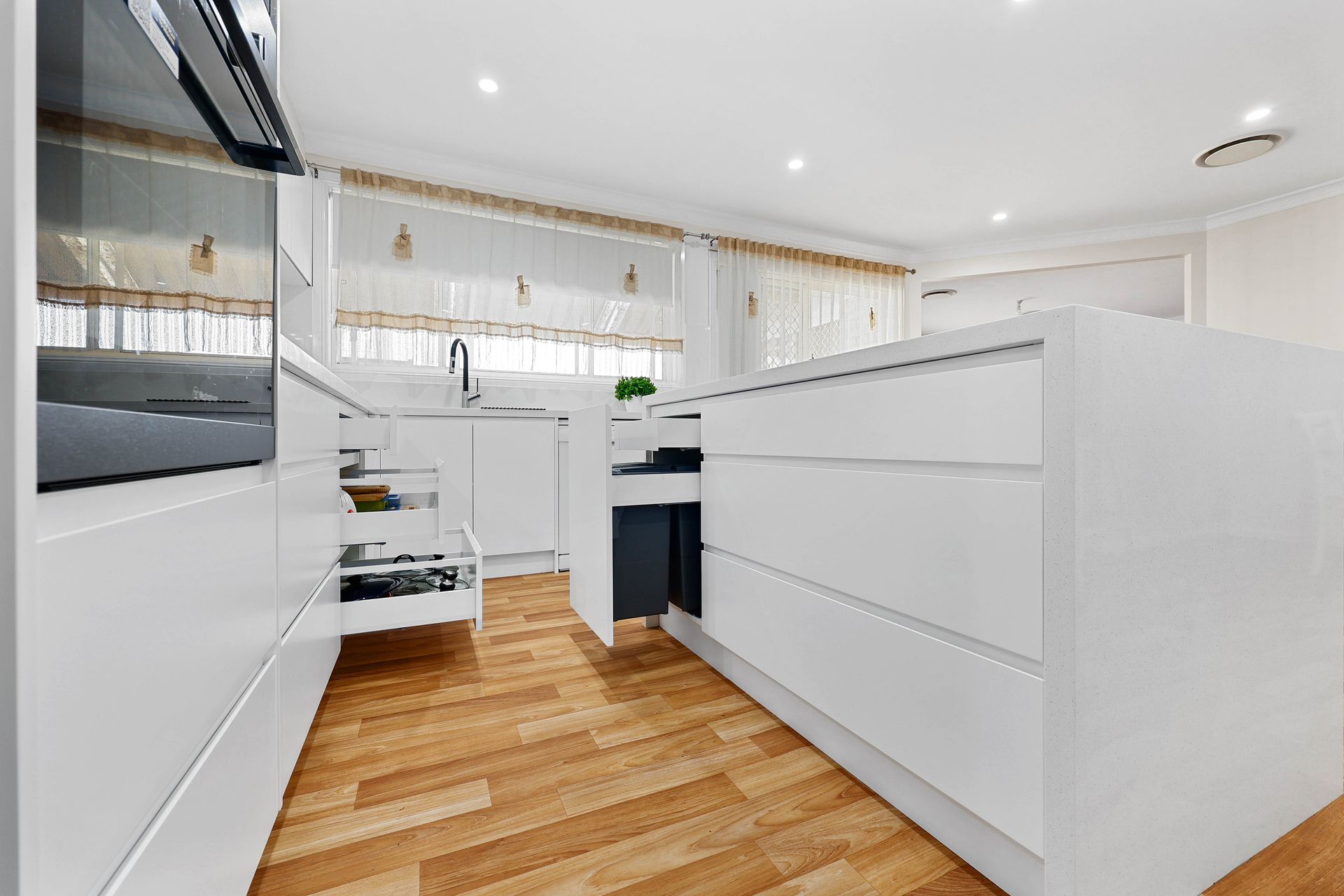 A Kitchen with Wood Floor, Island, and Gold Pendant Lights — Above & Beyond Interiors in Smeaton Grange, NSW