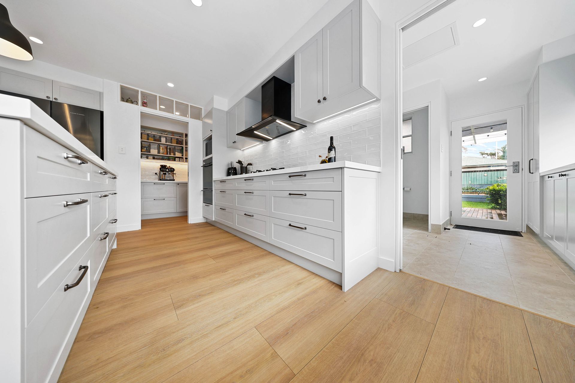 Bright Modern White Kitchen with Wood Floors — Above & Beyond Interiors in Smeaton Grange, NSW