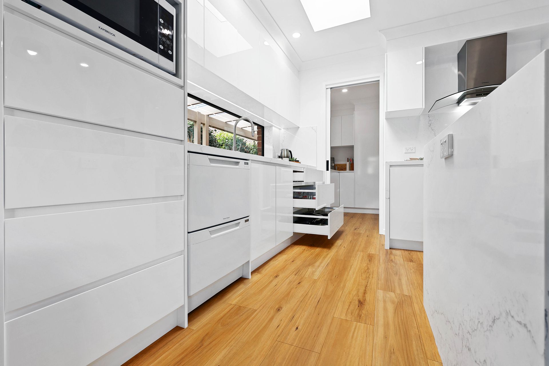 Bright White Modern Kitchen with Wood Floors — Above & Beyond Interiors in Smeaton Grange, NSW
