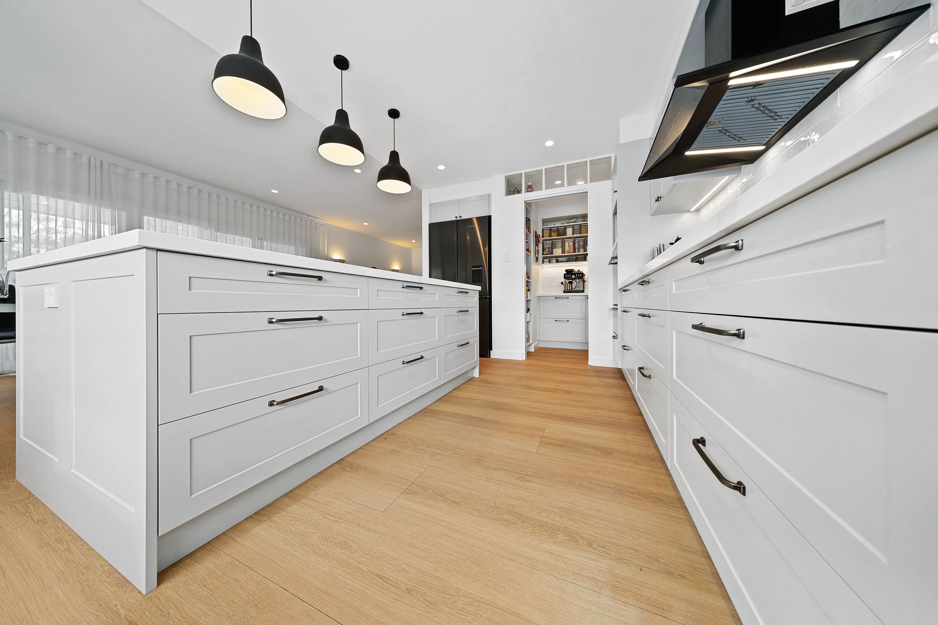 Bright Modern White Kitchen with Wood Floor — Above & Beyond Interiors in Smeaton Grange, NSW