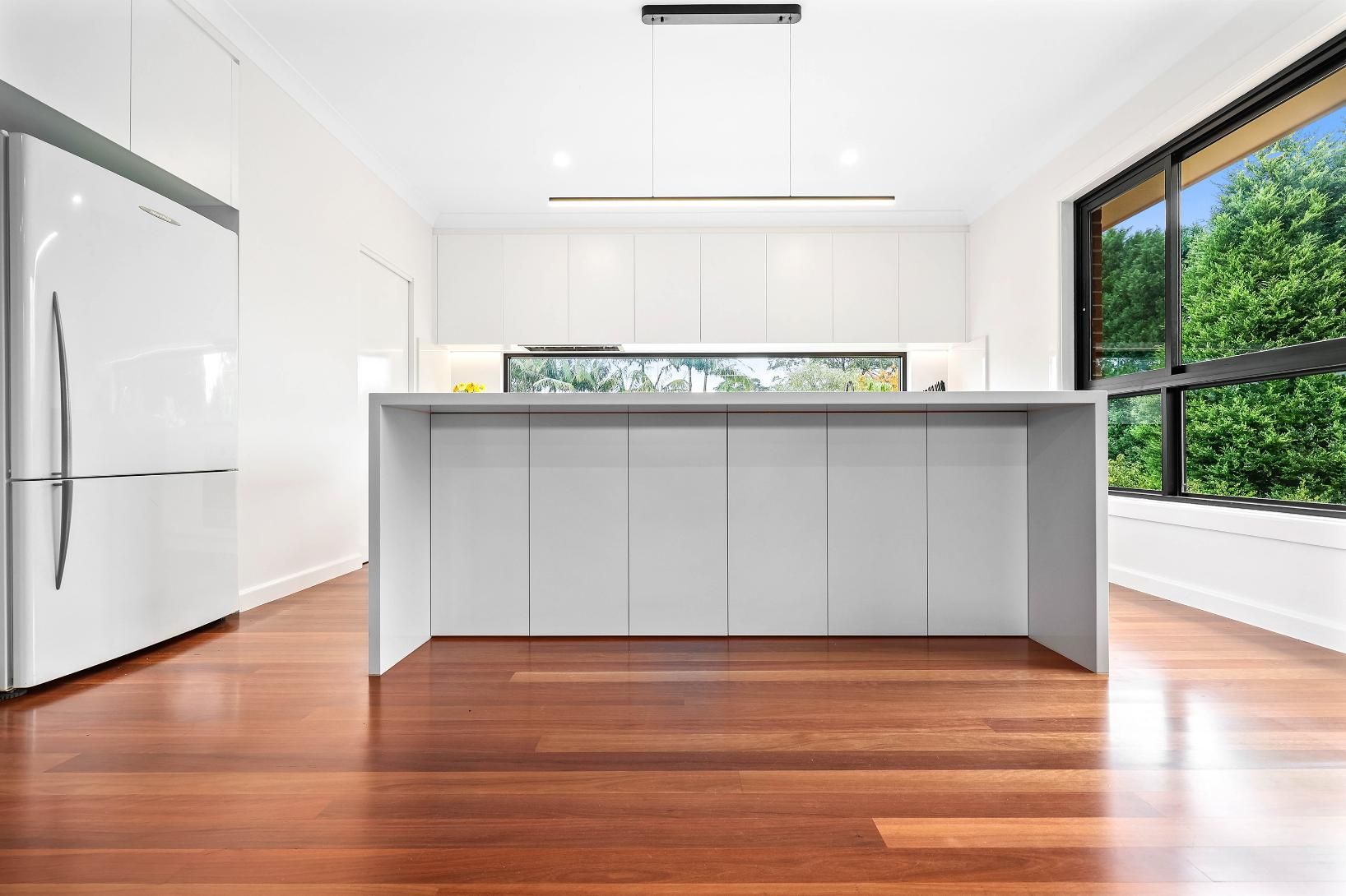Modern Kitchen with White Cabinets, Large Island — Above & Beyond Interiors in Smeaton Grange, NSW