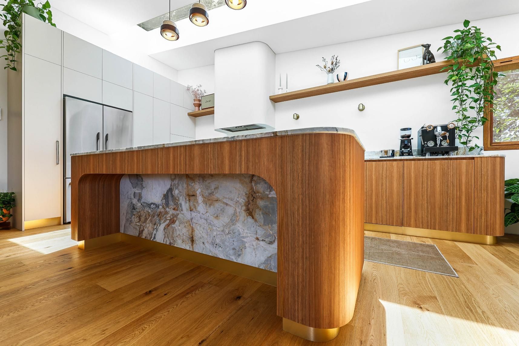 Modern Kitchen With a Curved Wooden Island — Above & Beyond Interiors in Smeaton Grange, NSW