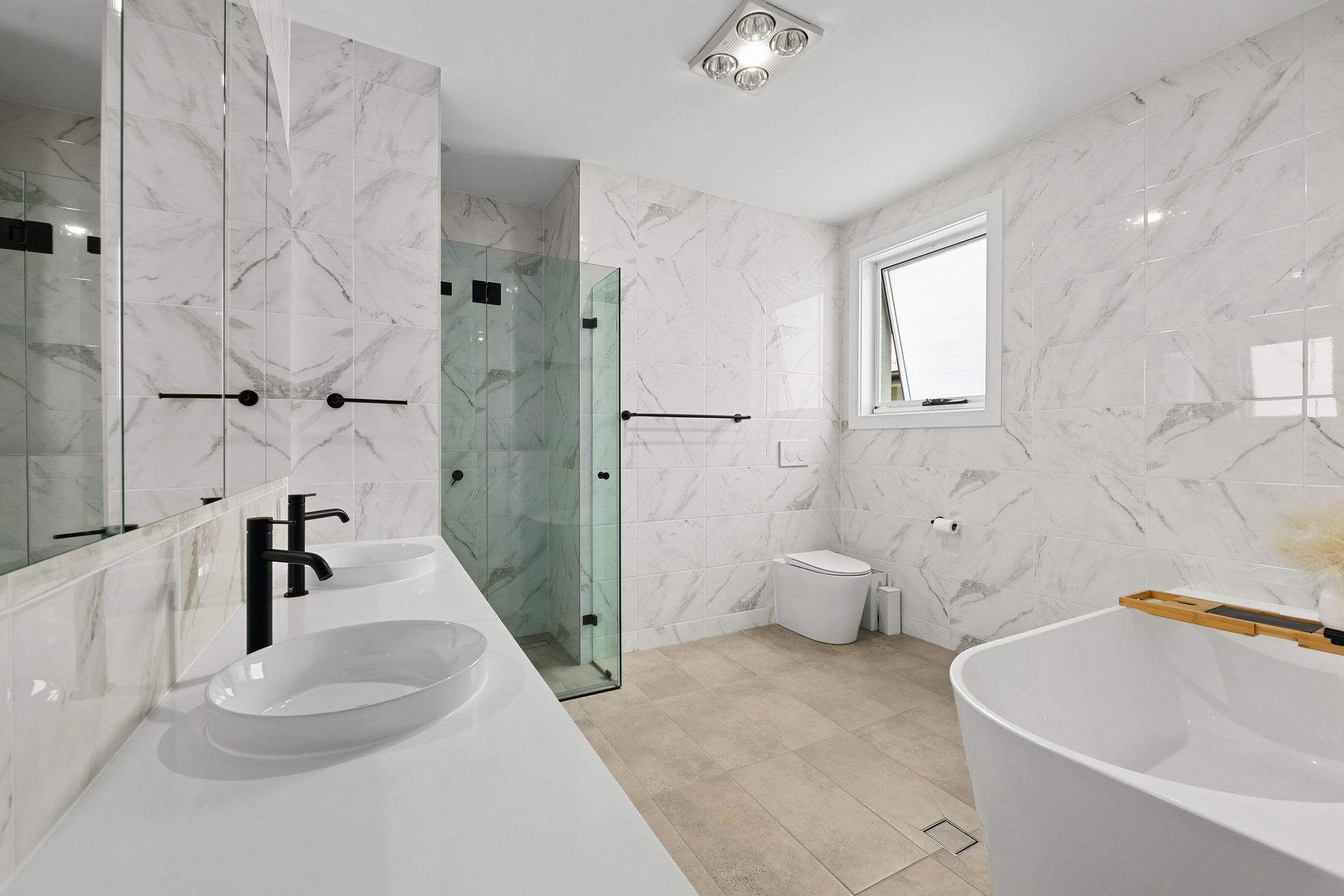 Modern white bathroom with marble walls, a glass shower, and a freestanding tub — Above & Beyond Interiors in Smeaton Grange, NSW