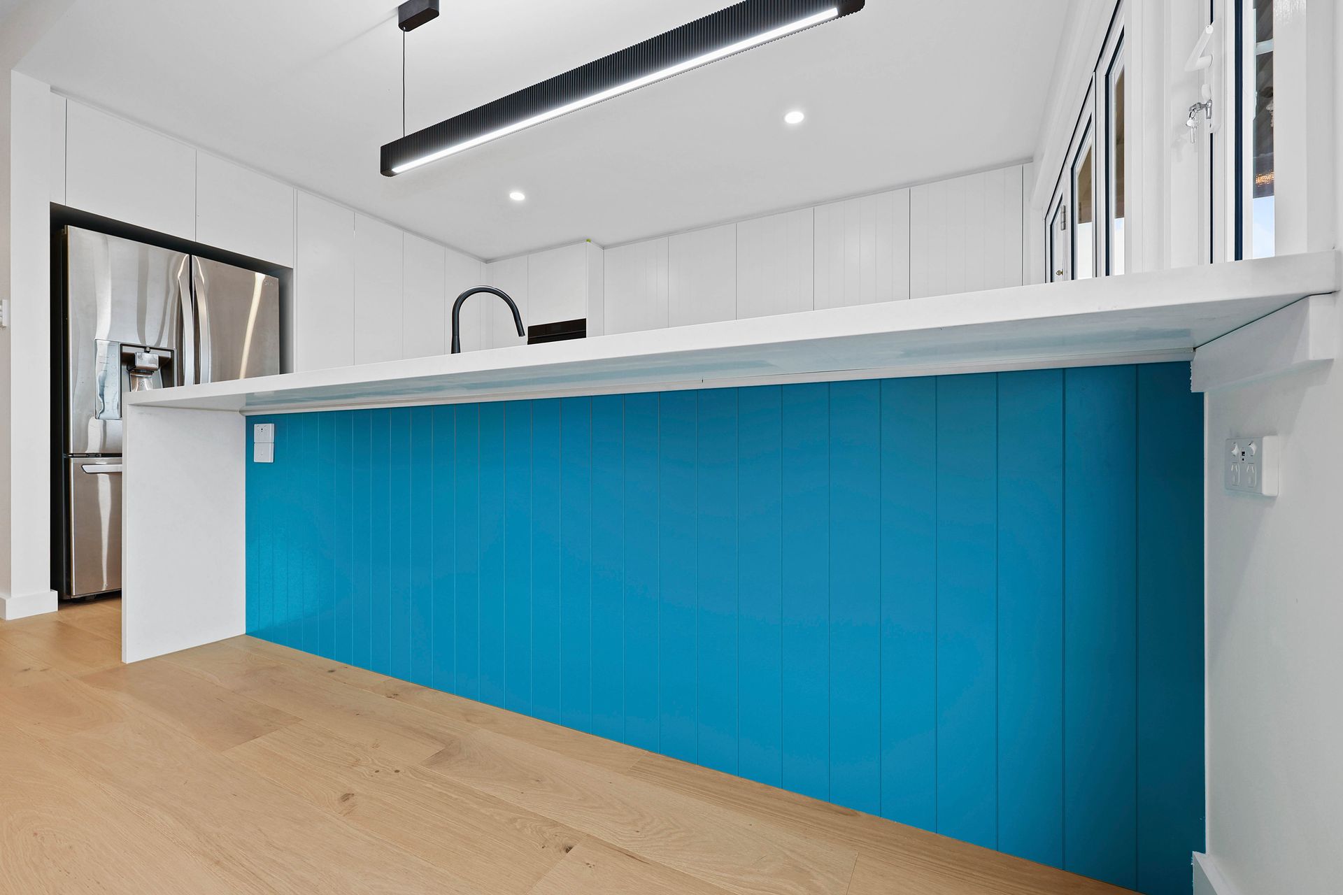 Modern Kitchen with Bright Blue Island Cabinetry — Above & Beyond Interiors in Smeaton Grange, NSW