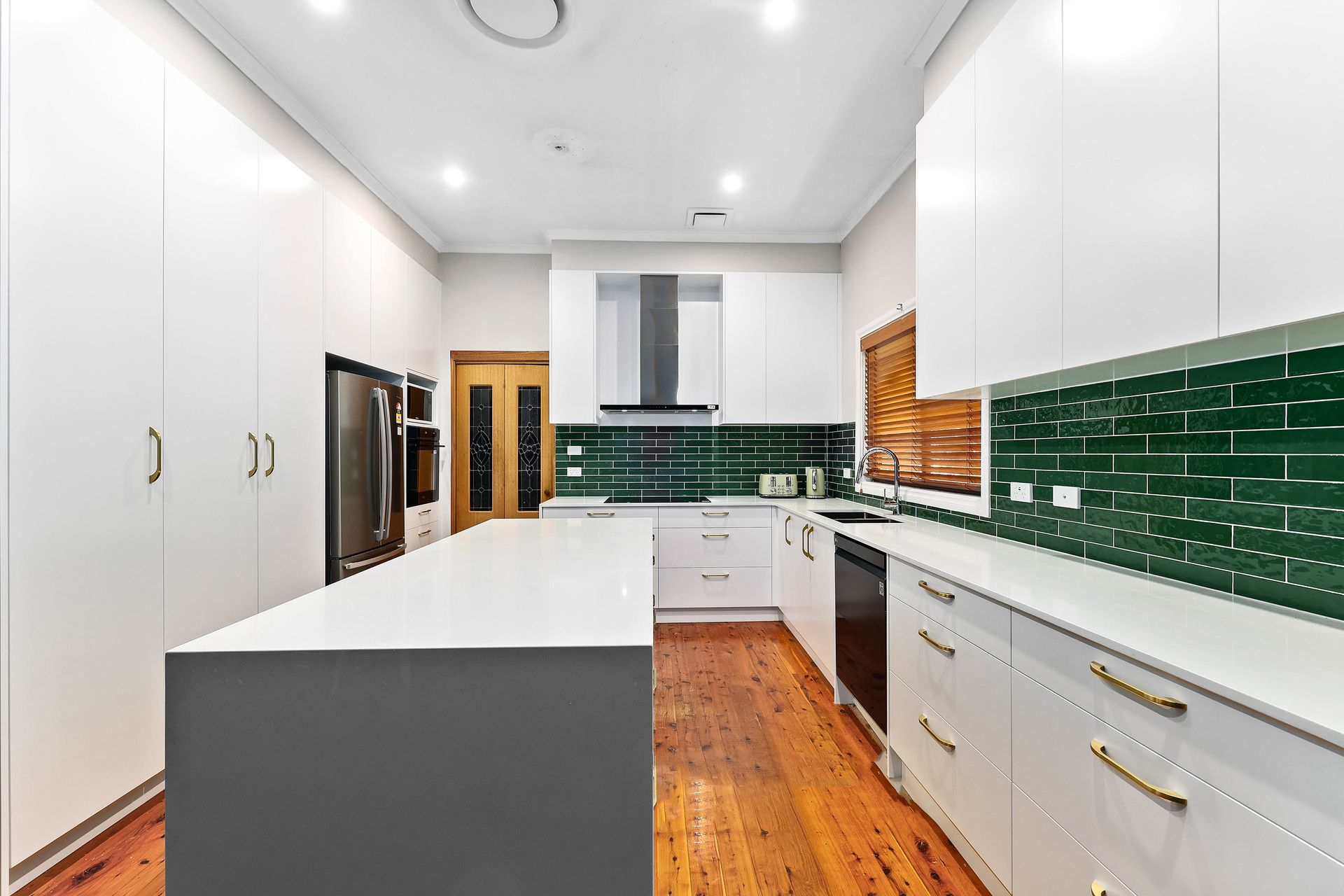 Modern White Kitchen with Dark Green Tile Backsplash — Above & Beyond Interiors in Smeaton Grange, NSW
