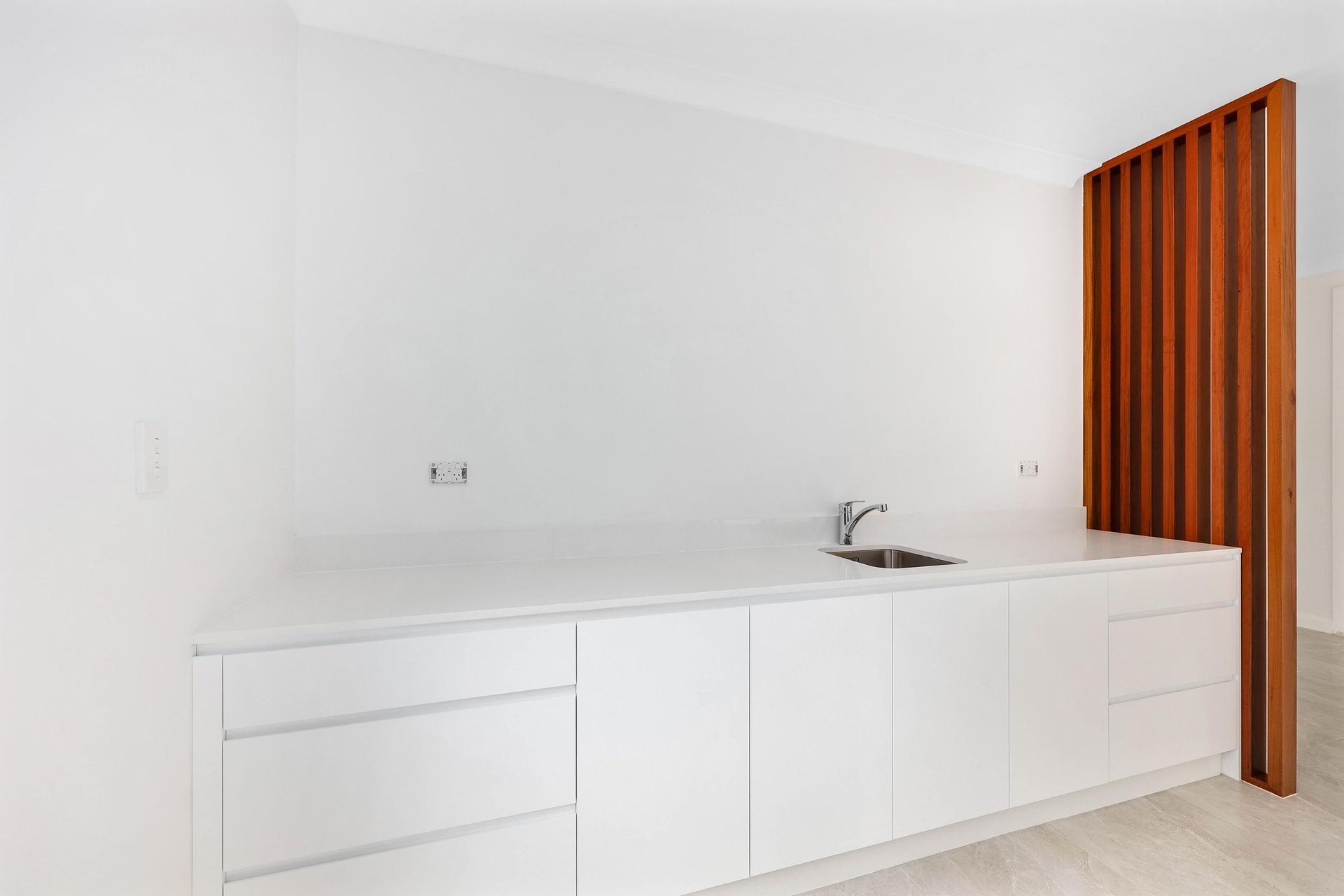 Minimal White Kitchen with Long Counter — Above & Beyond Interiors in Smeaton Grange, NSW