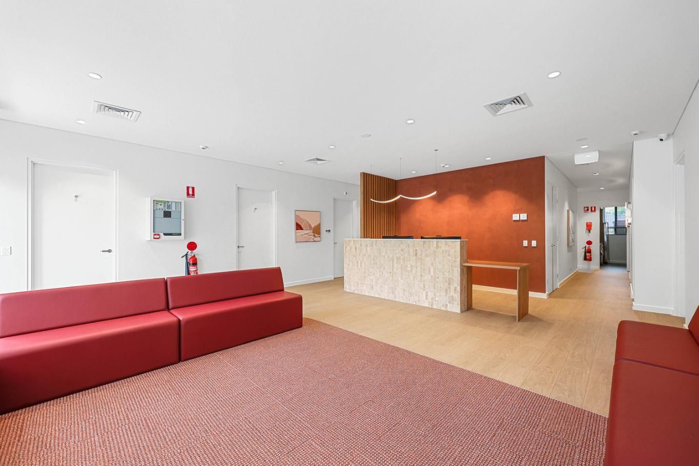 Modern Lobby With Red Seating, Reception Desk — Above & Beyond Interiors in Smeaton Grange, NSW