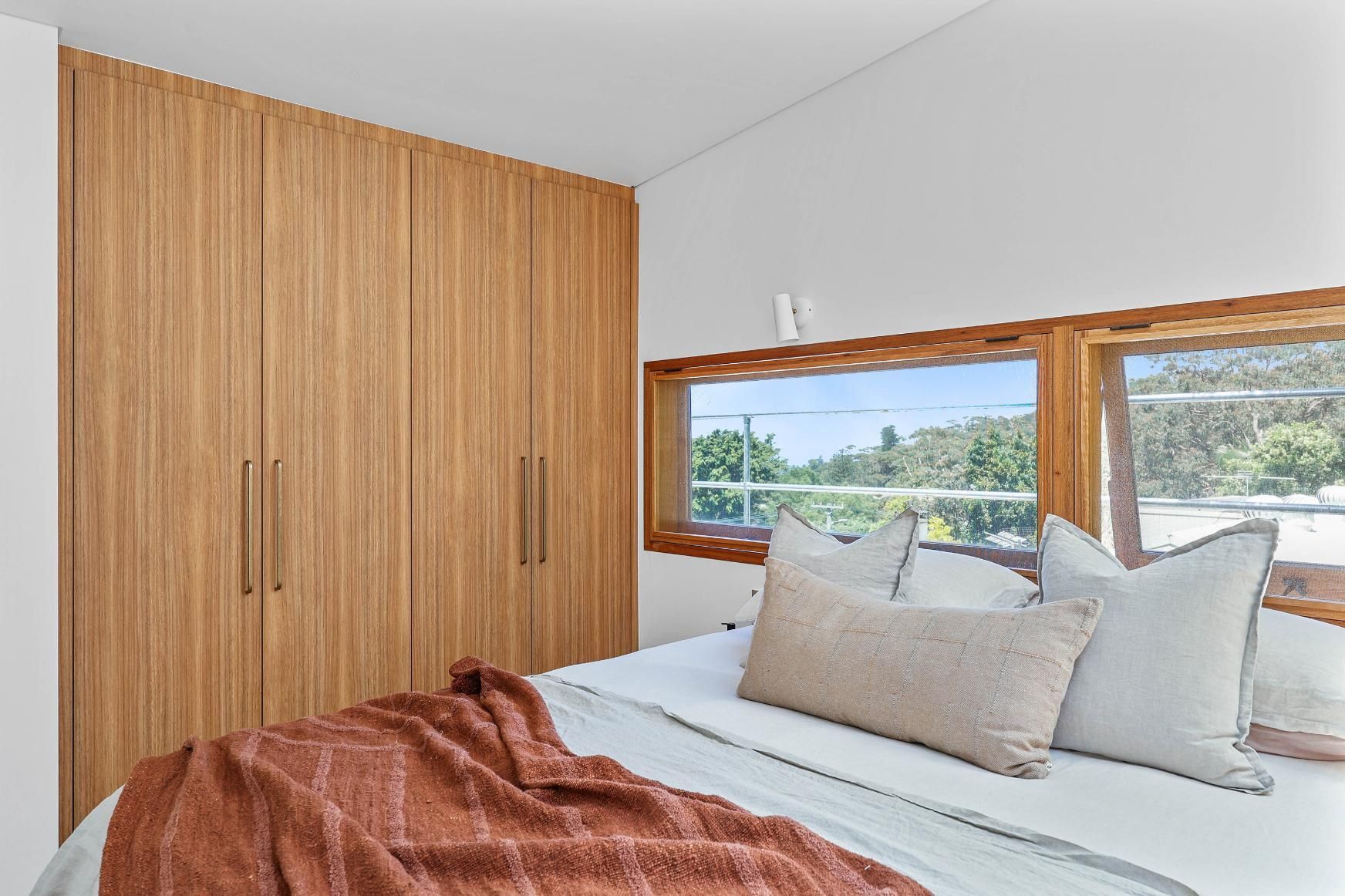 Bright Bedroom With Wood Wardrobe, White Bedding — Above & Beyond Interiors in Smeaton Grange, NSW