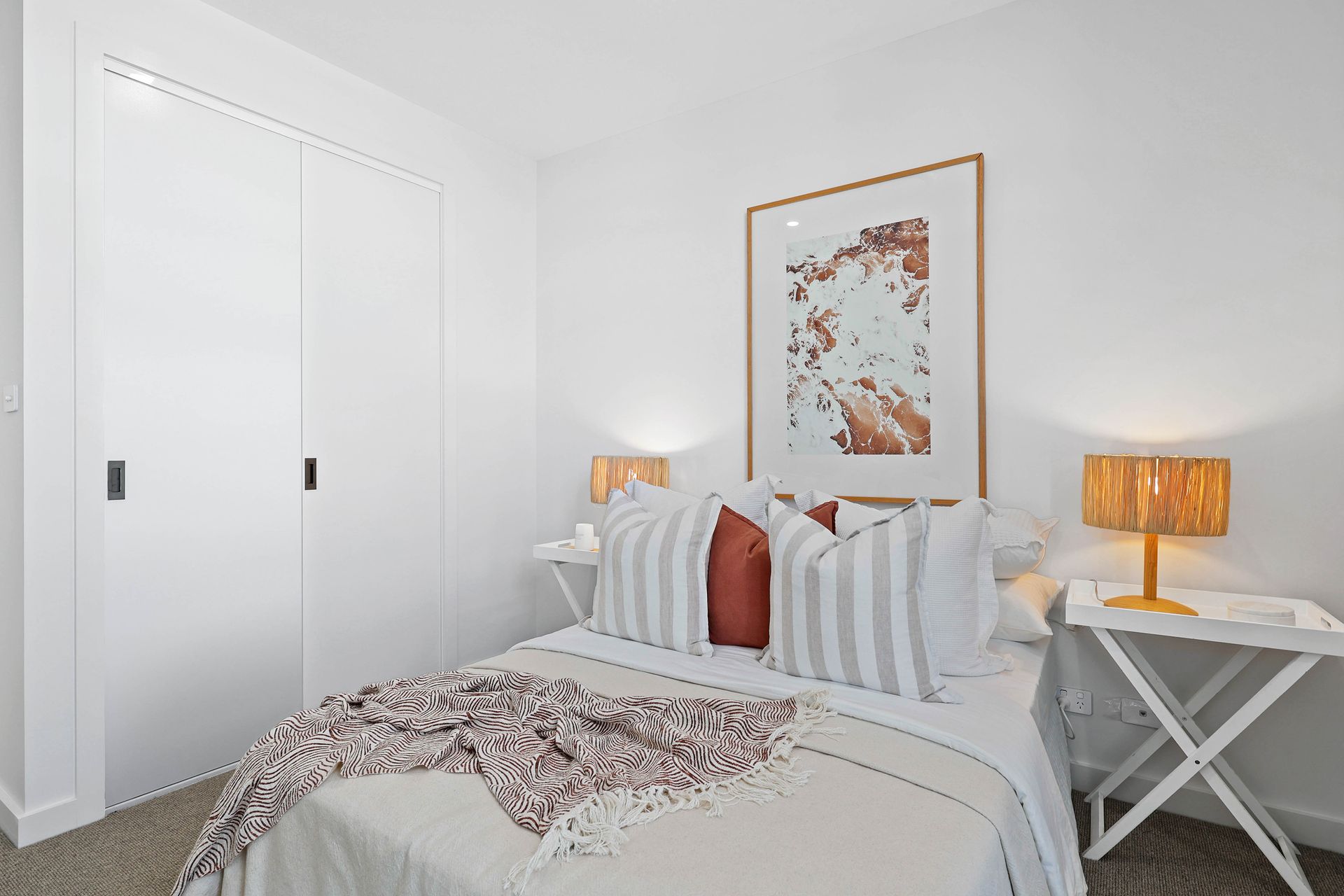 Bright White Bedroom With a Bed, Striped Pillows — Above & Beyond Interiors in Smeaton Grange, NSW