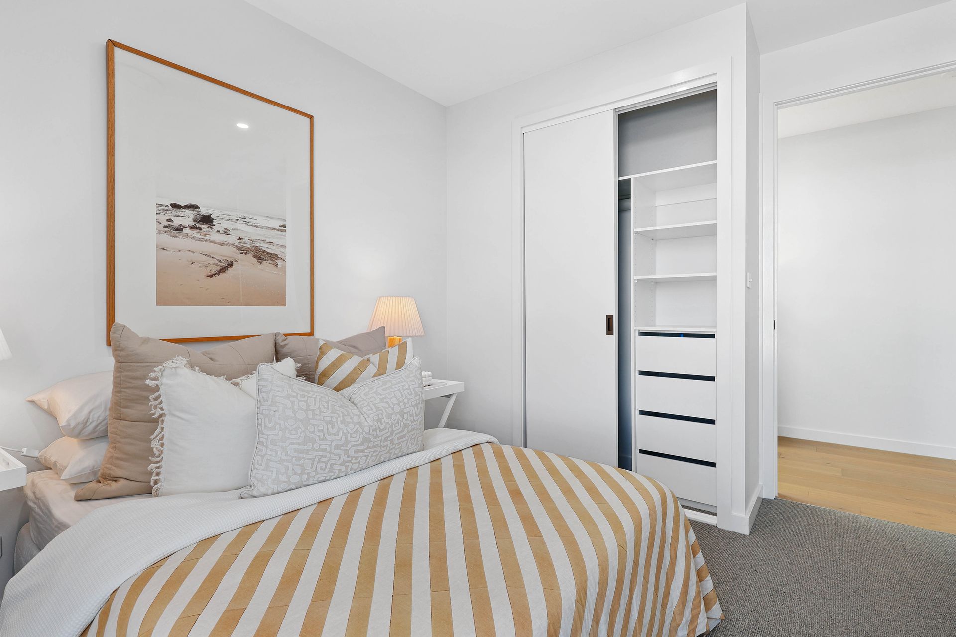 Bright Bedroom With a Striped Bed, Framed Wall Art — Above & Beyond Interiors in Smeaton Grange, NSW