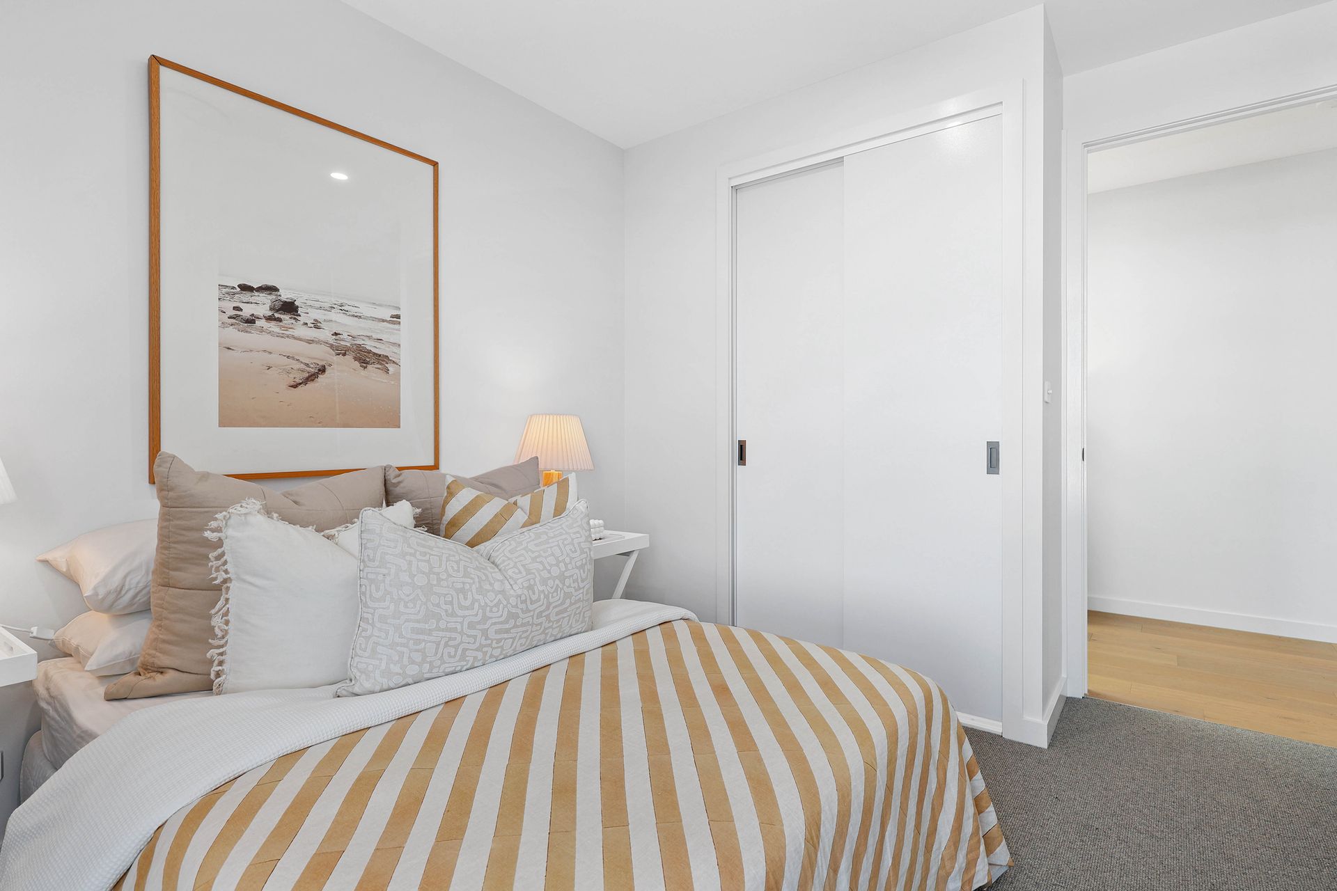 Bright Bedroom With Striped Bedding, Framed Wall Art — Above & Beyond Interiors in Smeaton Grange, NSW