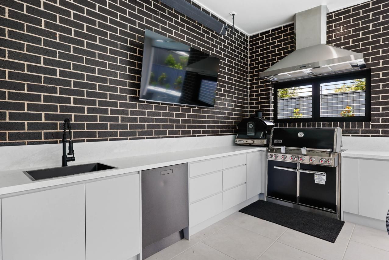 Modern Kitchen With Black Brick Backsplash — Above & Beyond Interiors in Smeaton Grange, NSW
