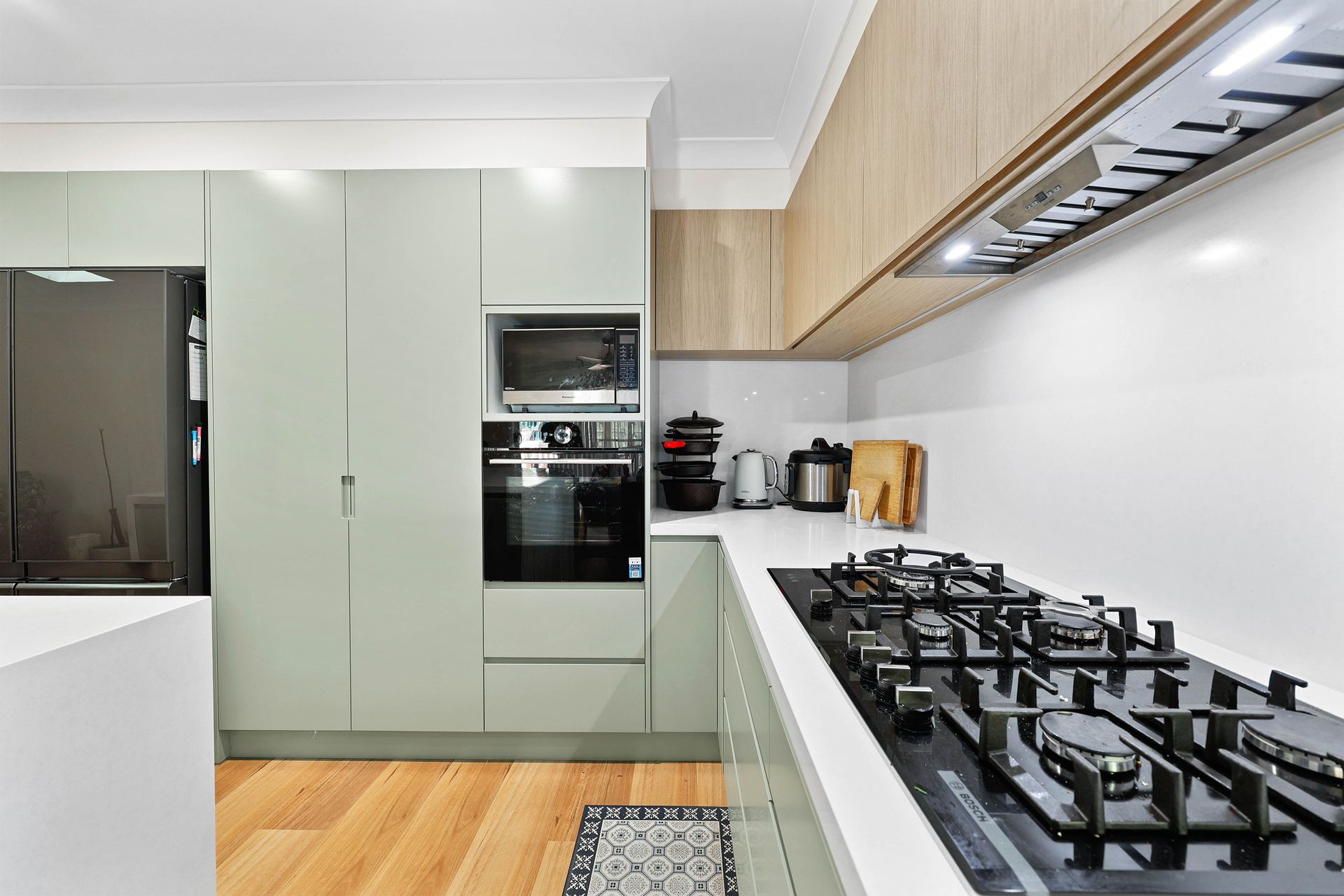Modern Kitchen with Pale Green Cabinets — Above & Beyond Interiors in Smeaton Grange, NSW