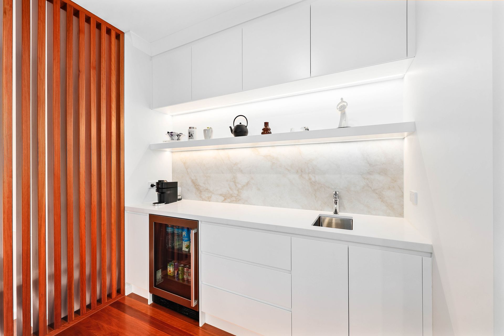 Modern White Kitchen with Wood Slat Divider — Above & Beyond Interiors in Smeaton Grange, NSW