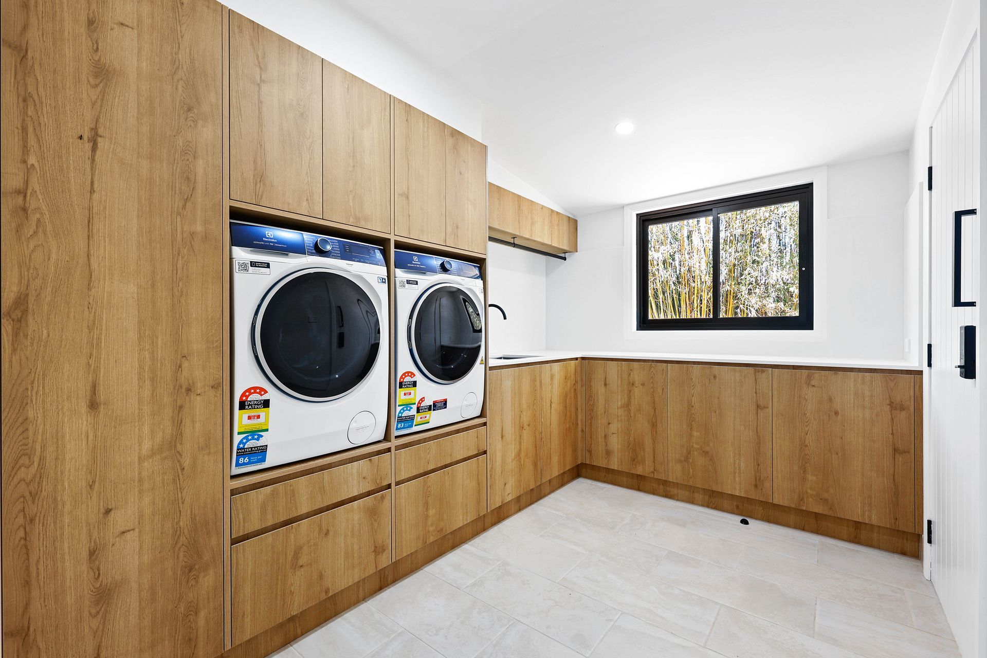 Laundry Room with Front-Load Washer and Dryer — Above & Beyond Interiors in Smeaton Grange, NSW