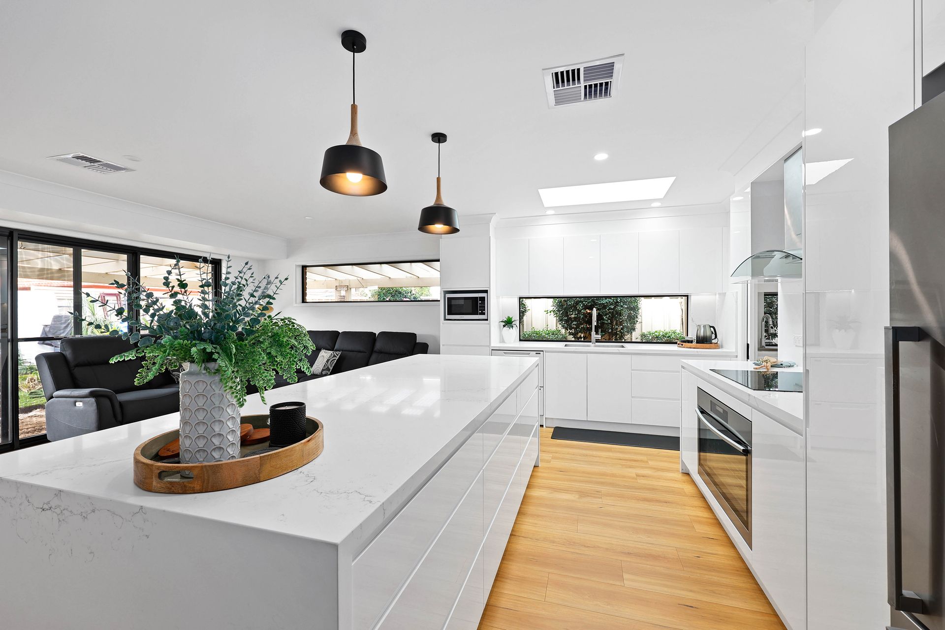 A Kitchen with Wood Floor, and Large Windows — Above & Beyond Interiors in Smeaton Grange, NSW
