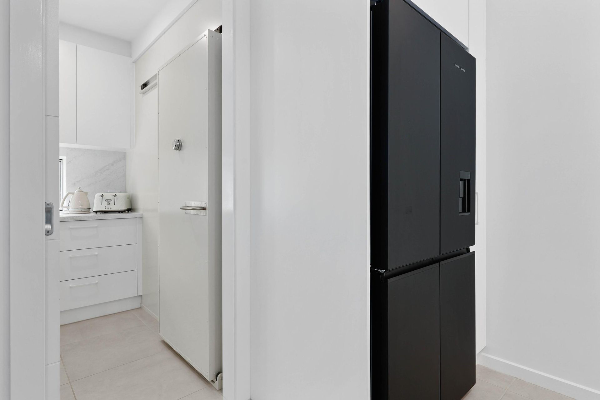 White Hallway With a Black Refrigerator — Above & Beyond Interiors in Smeaton Grange, NSW