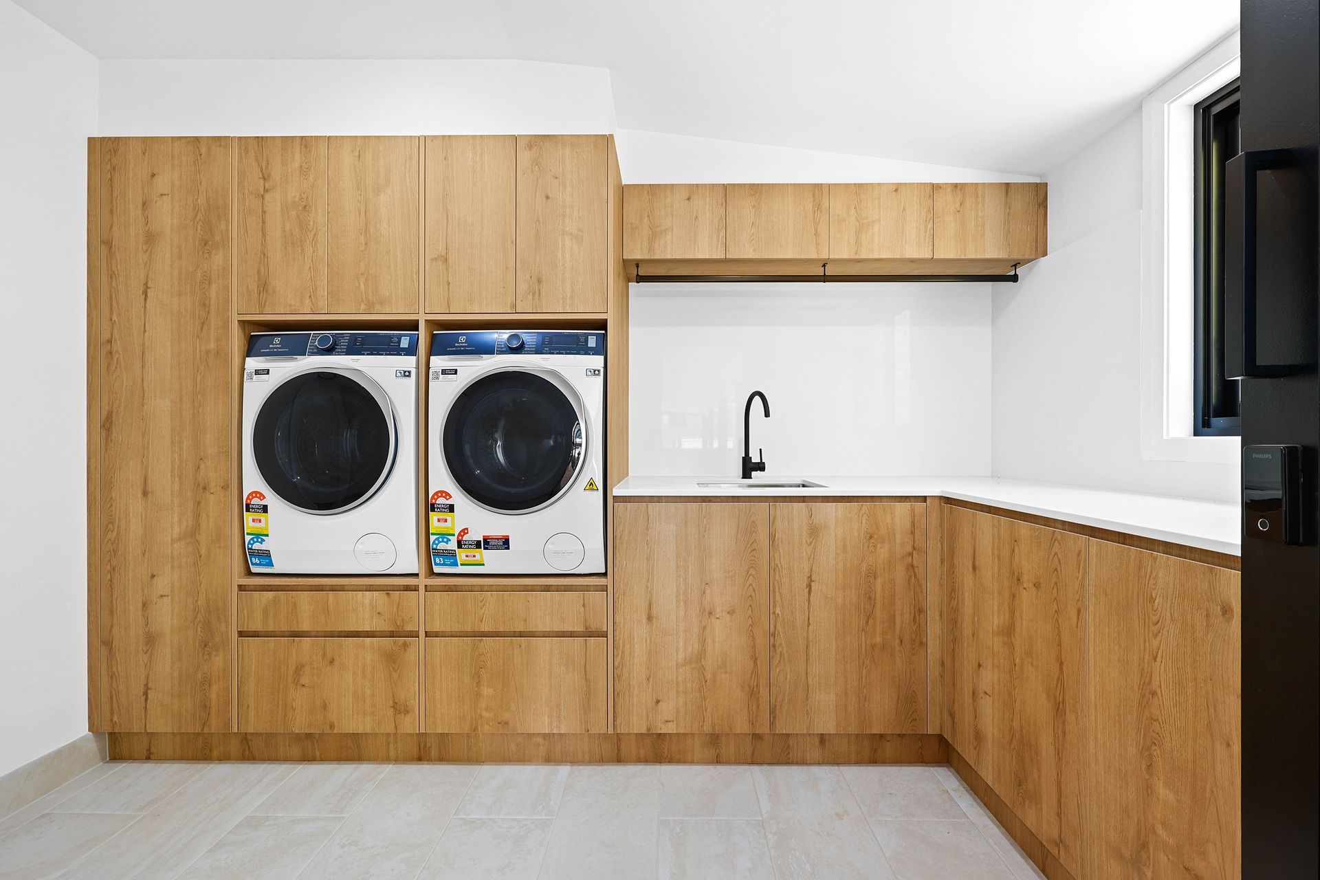 Modern Laundry Room with Wood Cabinets — Above & Beyond Interiors in Smeaton Grange, NSW