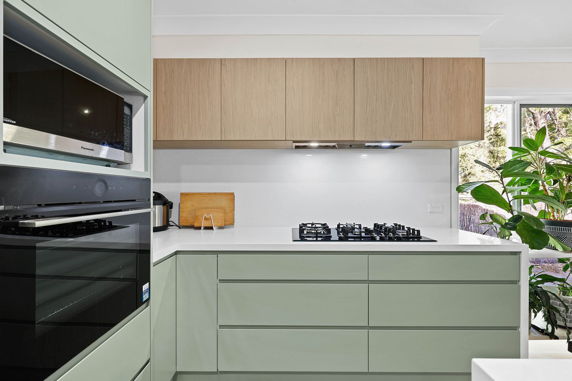 Modern Kitchen With Light Green Cabinets — Above & Beyond Interiors in Smeaton Grange, NSW