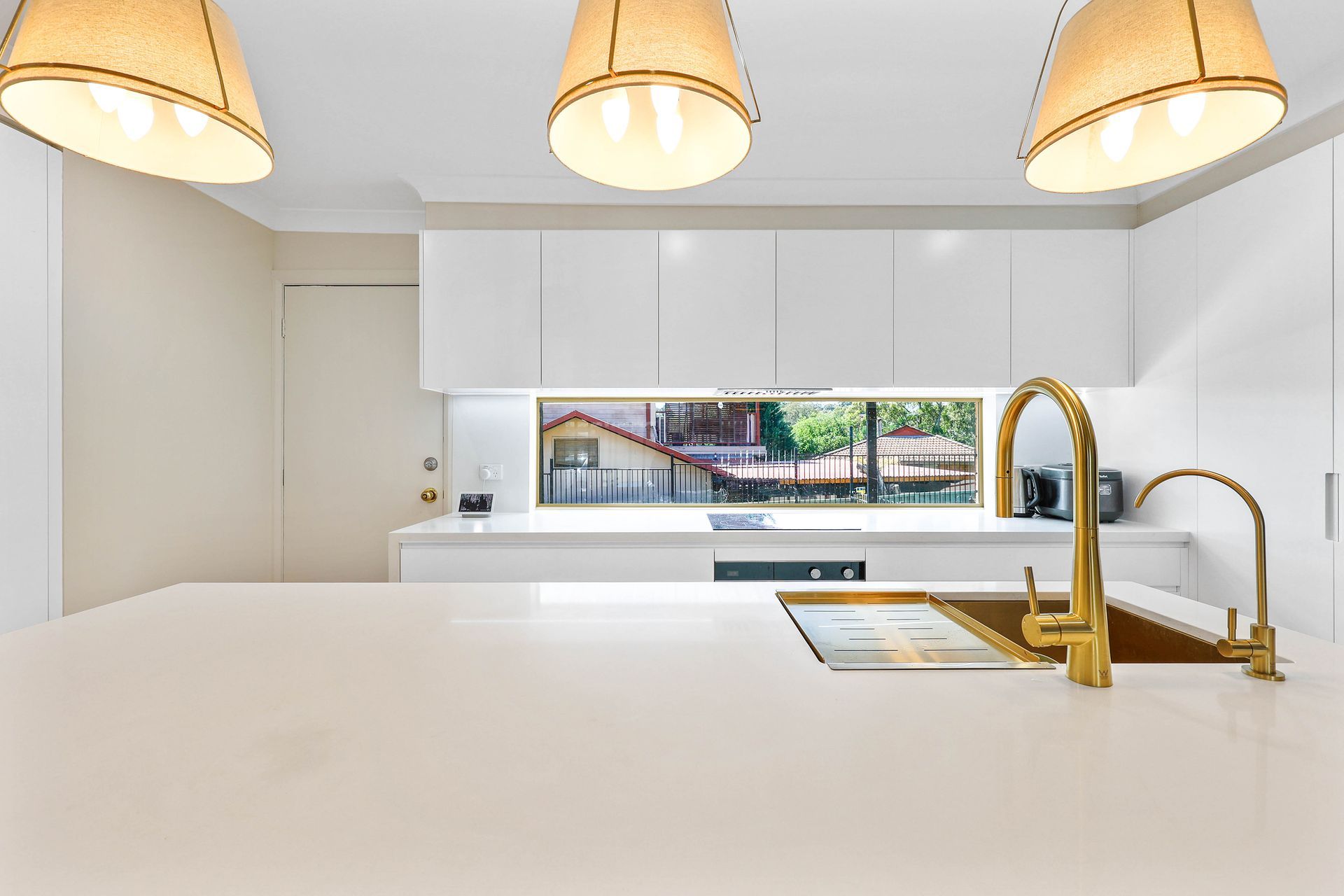 Modern White Kitchen With Gold Faucet — Above & Beyond Interiors in Smeaton Grange, NSW