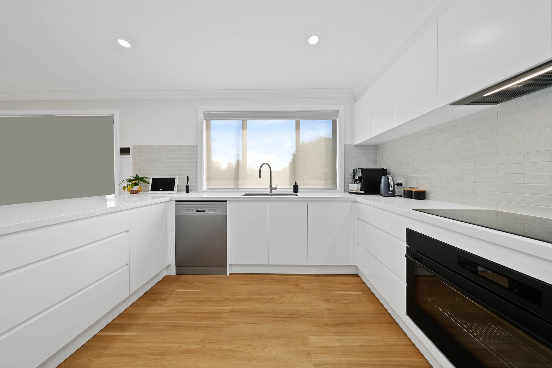 Modern White Kitchen with Wood Floor — Above & Beyond Interiors in Smeaton Grange, NSW