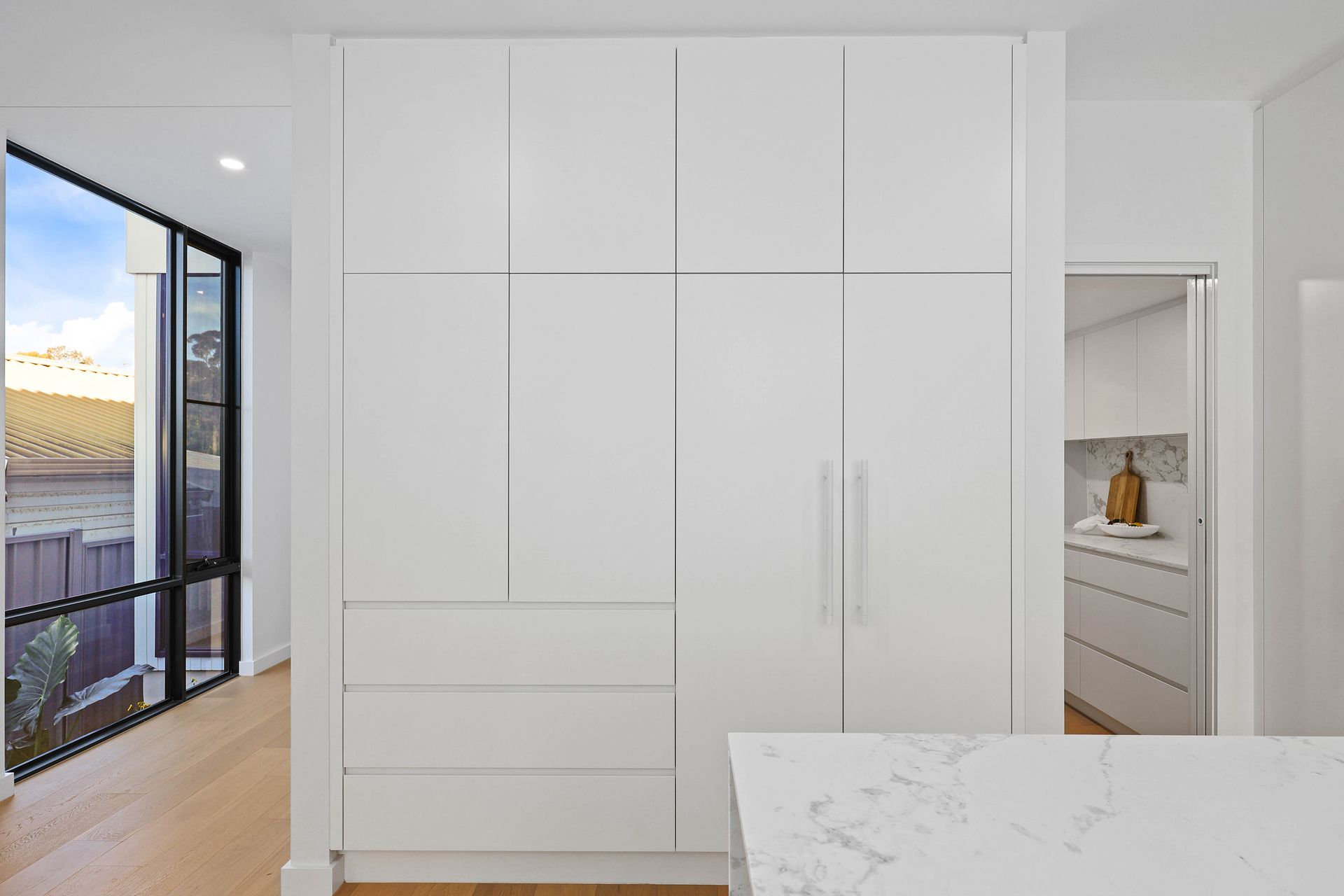 Bright White Built-in Closet With Double Doors in a Modern Room — Above & Beyond Interiors in Smeaton Grange, NSW