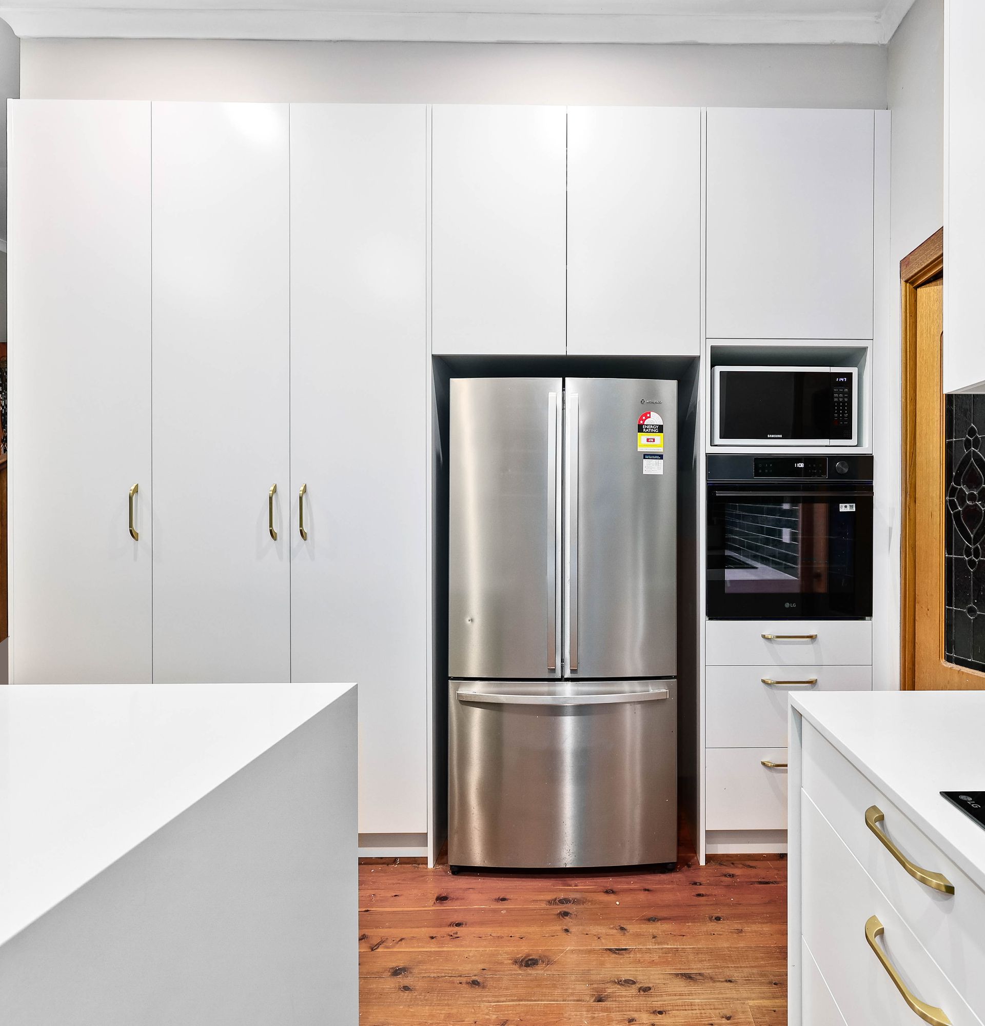 Modern Kitchen with White Cabinets and  Stainless Steel Refrigerator — Above & Beyond Interiors in Smeaton Grange, NSW