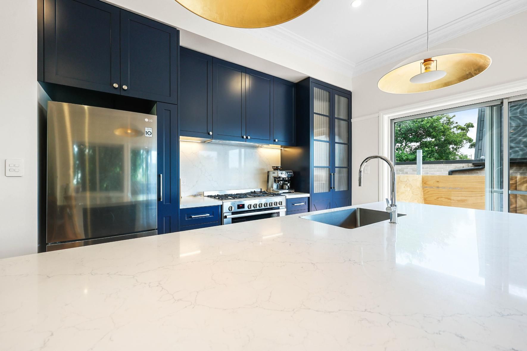Modern Kitchen With Dark Blue Cabinets — Above & Beyond Interiors in Smeaton Grange, NSW
