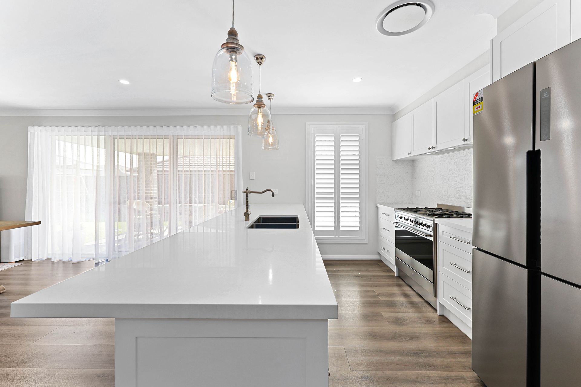 Bright White Modern Kitchen with Wood Flooring — Above & Beyond Interiors in Smeaton Grange, NSW