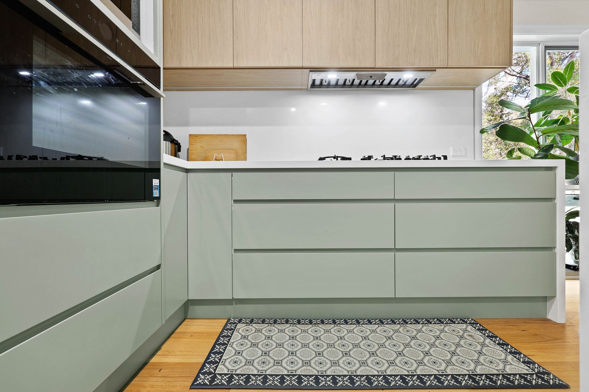 Modern Kitchen with Pale Green Cabinets — Above & Beyond Interiors in Smeaton Grange, NSW