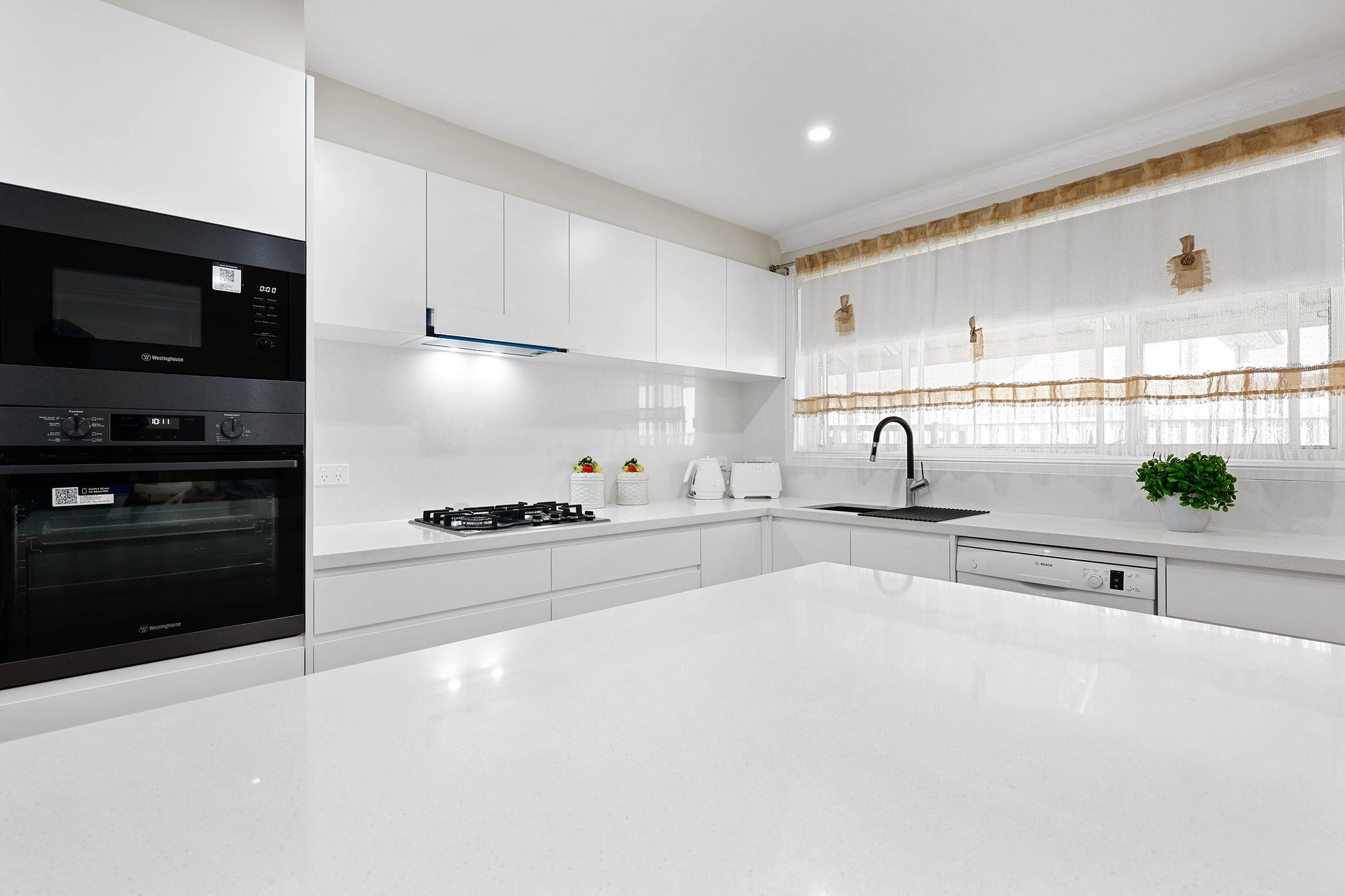 Bright Modern White Kitchen with Glossy Island — Above & Beyond Interiors in Smeaton Grange, NSW