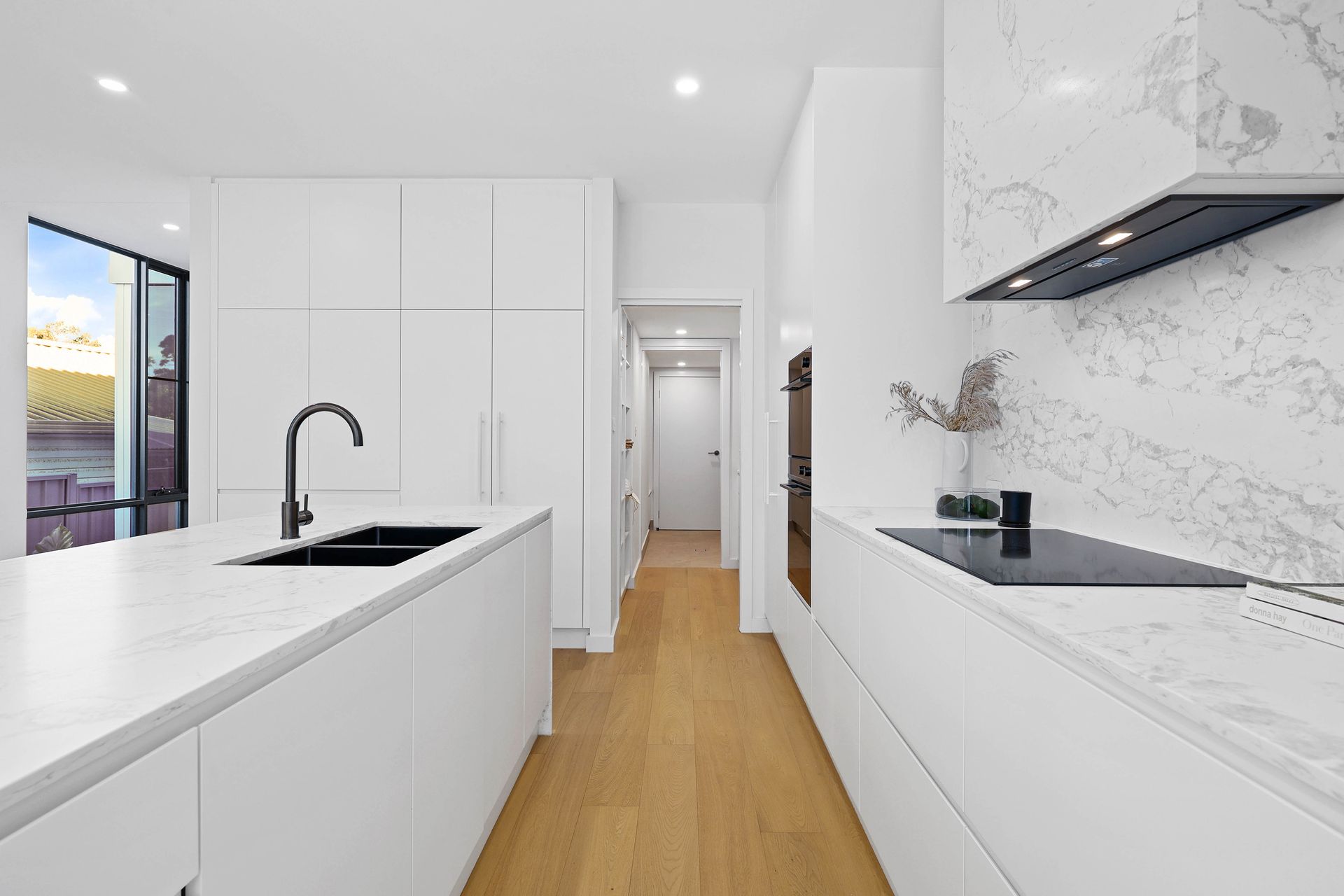 Modern White Kitchen With Marble Countertops — Above & Beyond Interiors in Smeaton Grange, NSW