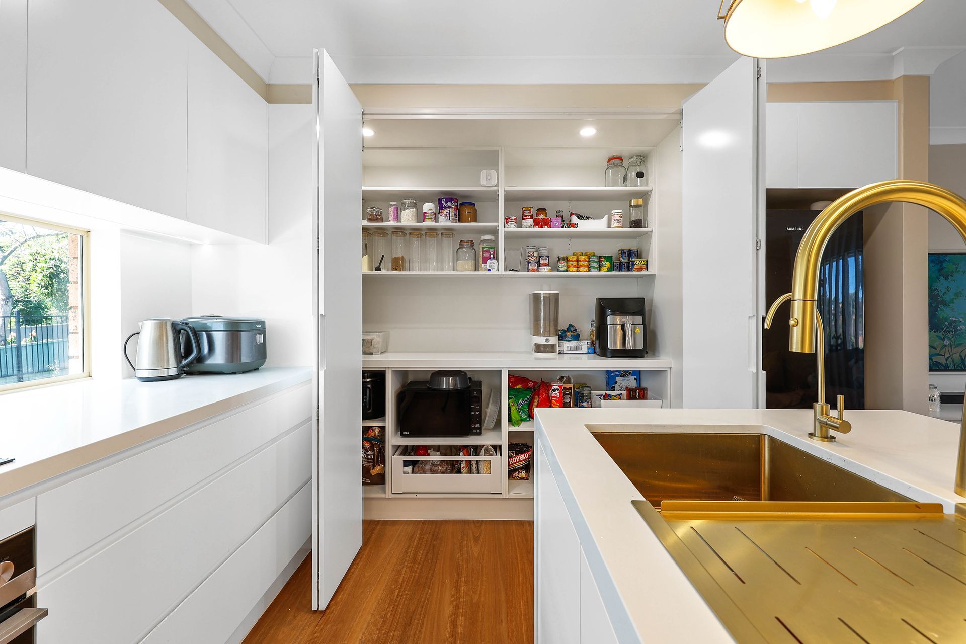 Bright White Kitchen With Wood Floor, Gold Faucet — Above & Beyond Interiors in Smeaton Grange, NSW