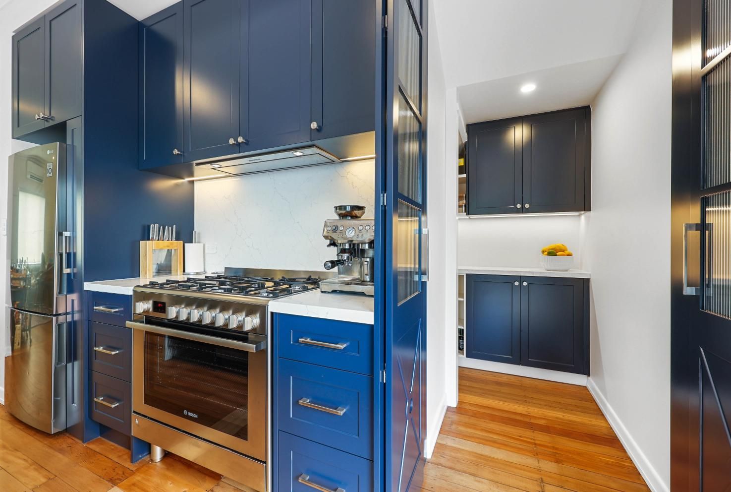 Modern Kitchen With Navy Cabinets, Stainless Appliances — Above & Beyond Interiors in Smeaton Grange, NSW
