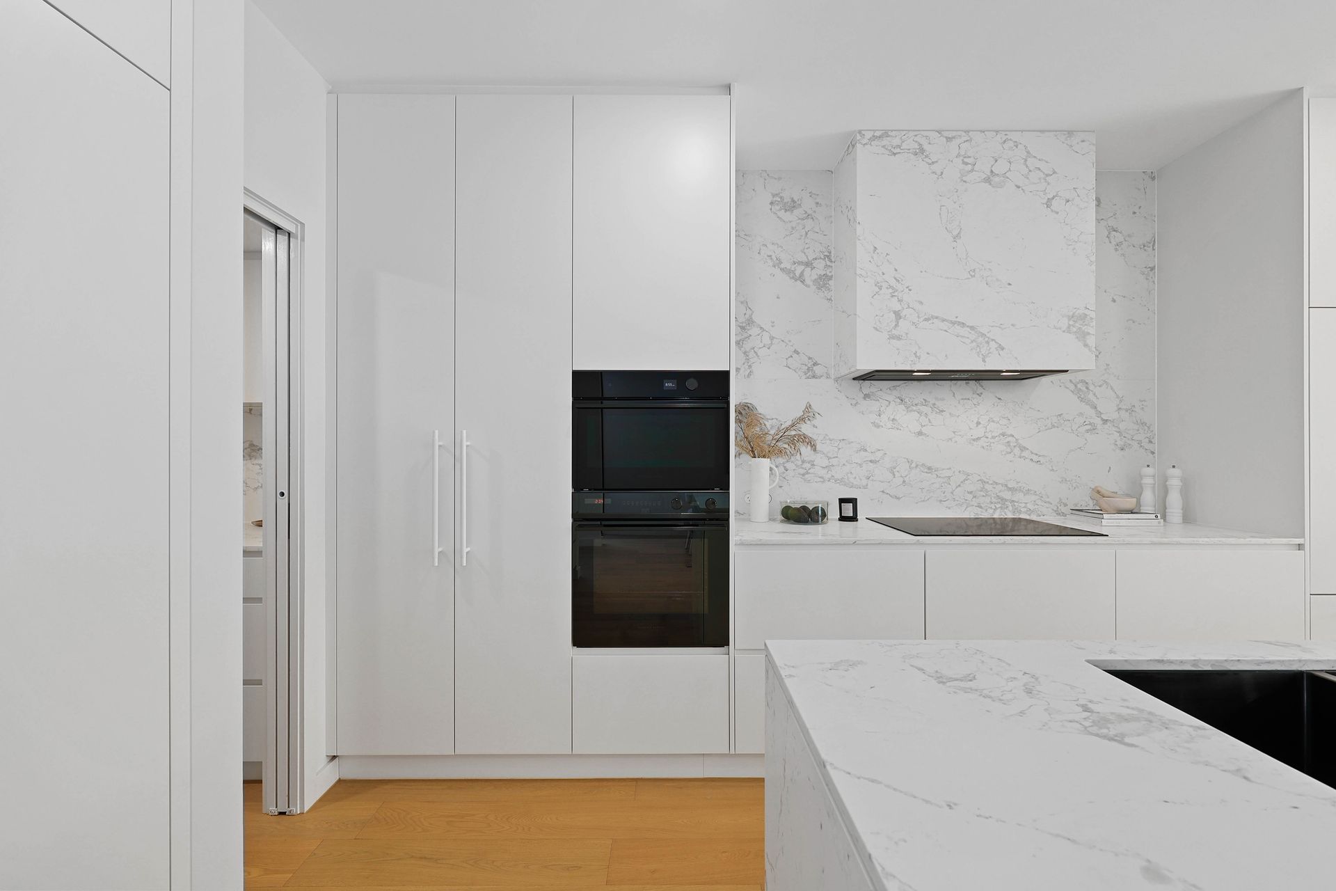Modern White Kitchen With Marble Countertops — Above & Beyond Interiors in Smeaton Grange, NSW