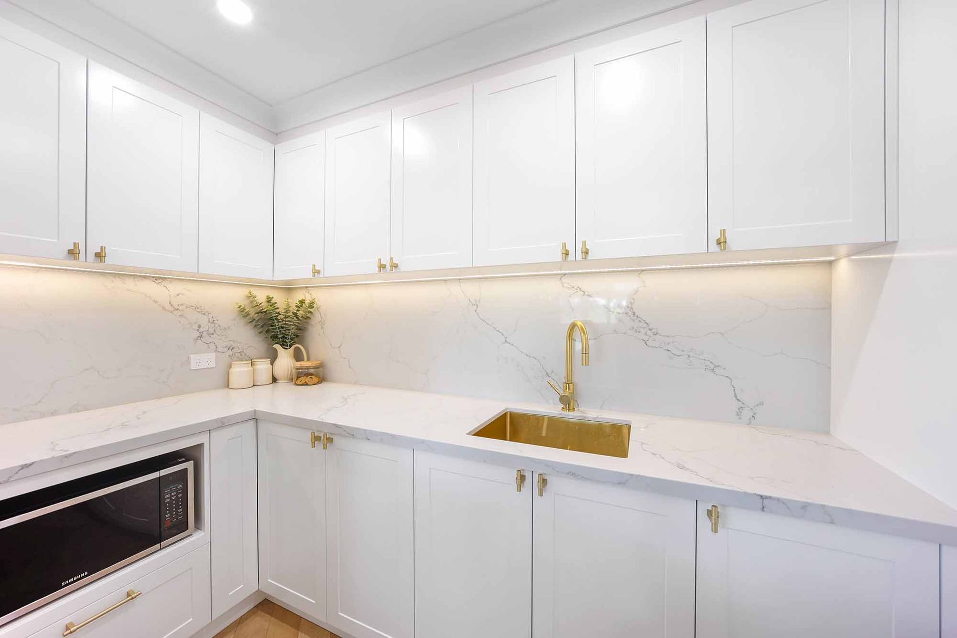 Bright White Kitchen With Marble Countertops — Above & Beyond Interiors in Smeaton Grange, NSW
